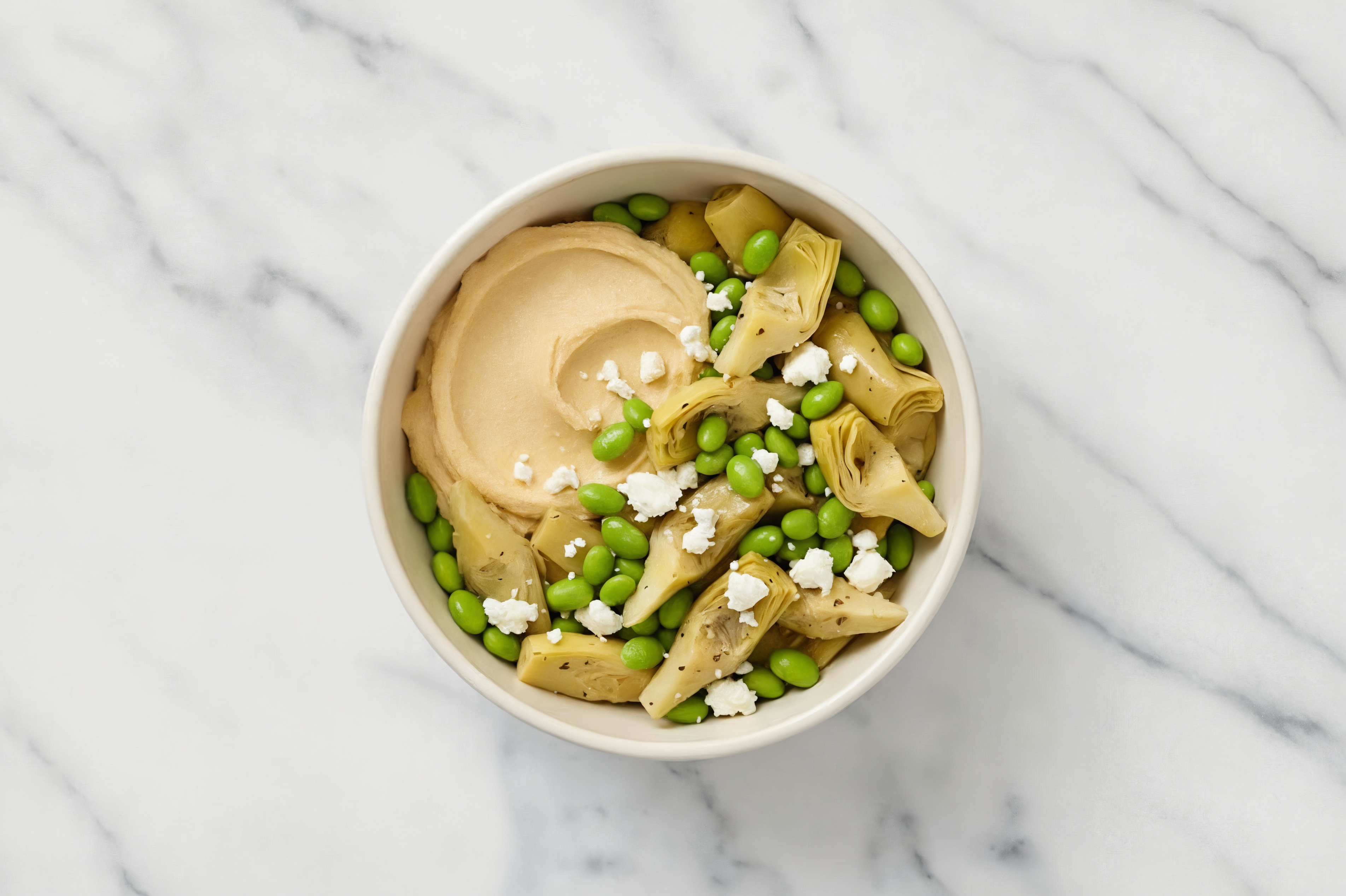 Crumbled Chevre Artichoke Edamame Bowl over Lemon Garlic Hummus