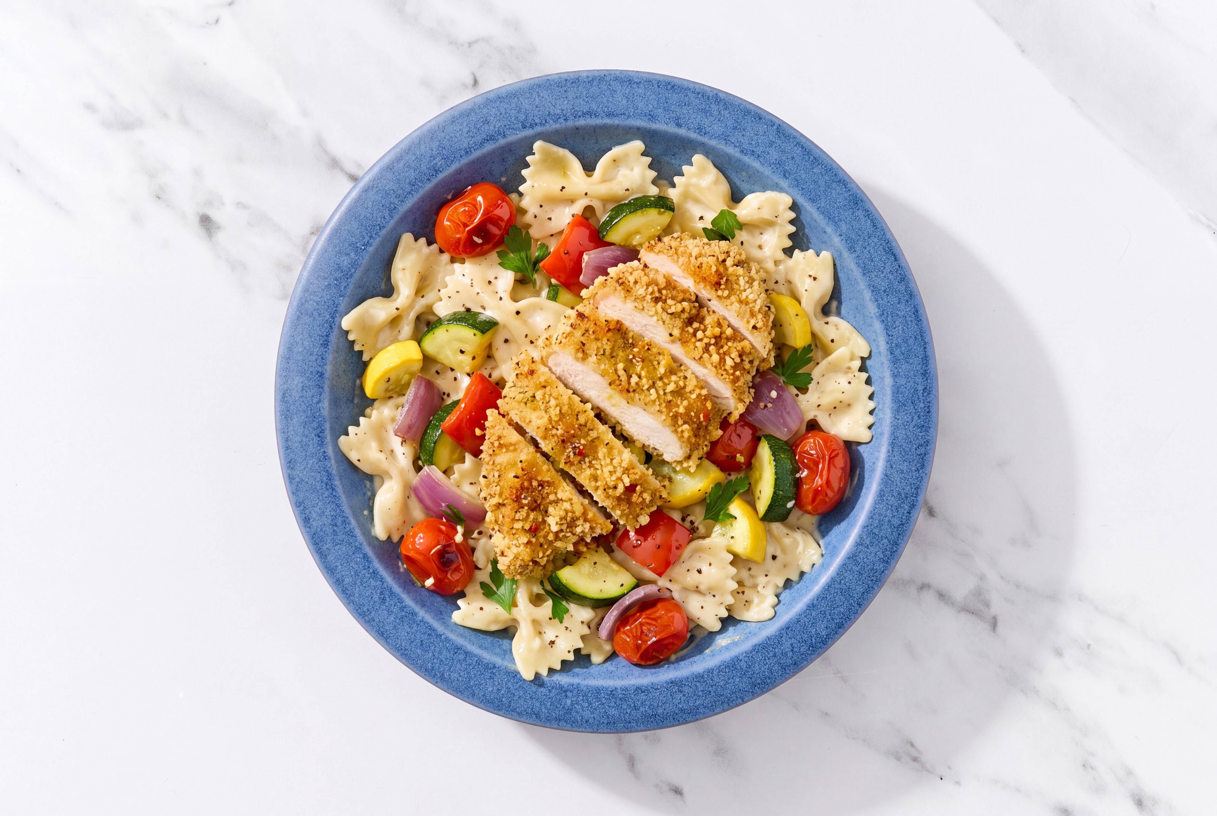 Crispy Garlic Chicken over Alfredo Farfalle with Mixed Veggies