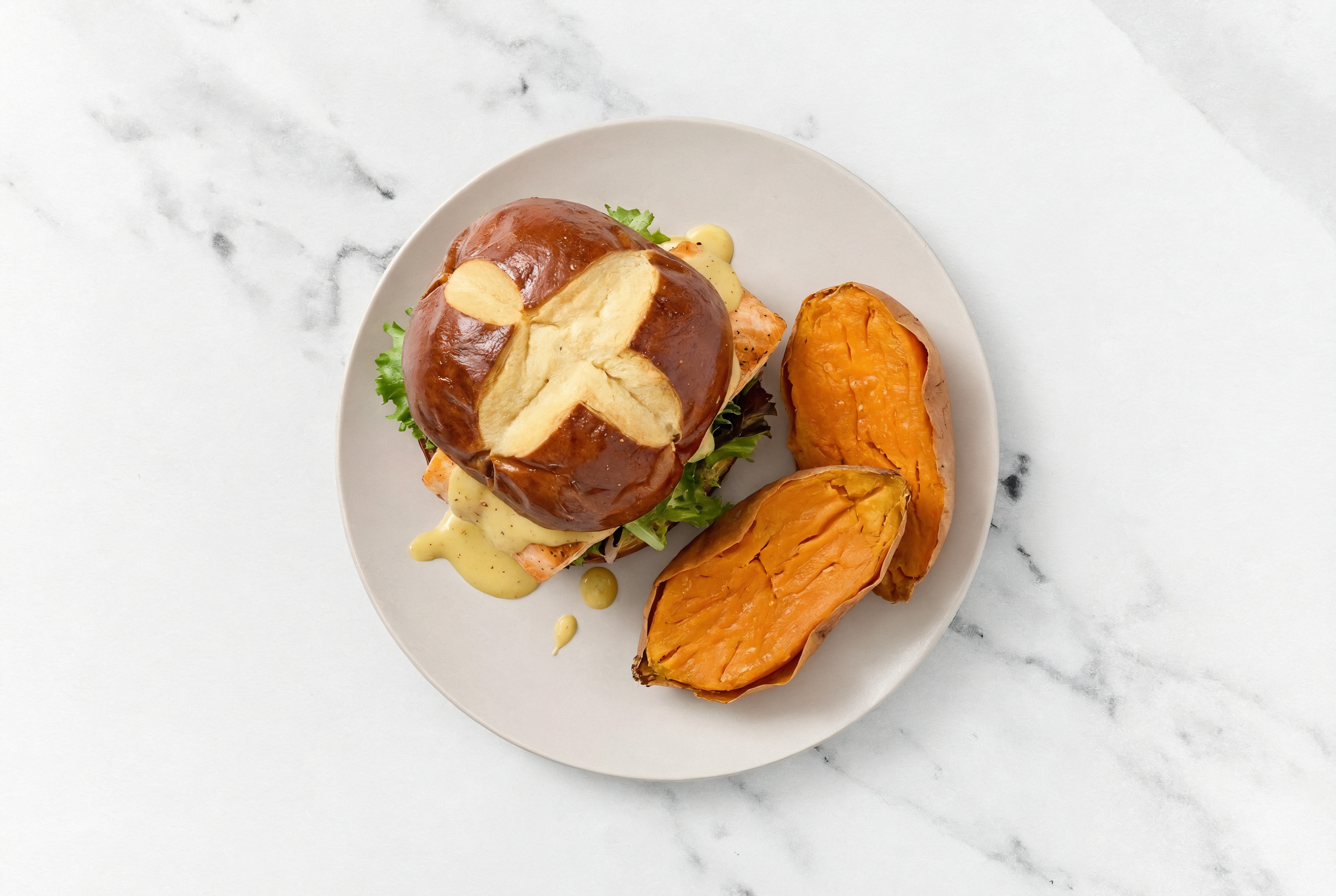Honey Mustard Salmon Sandwich on Pretzel Bun with Spring Mix + Sweet Potato