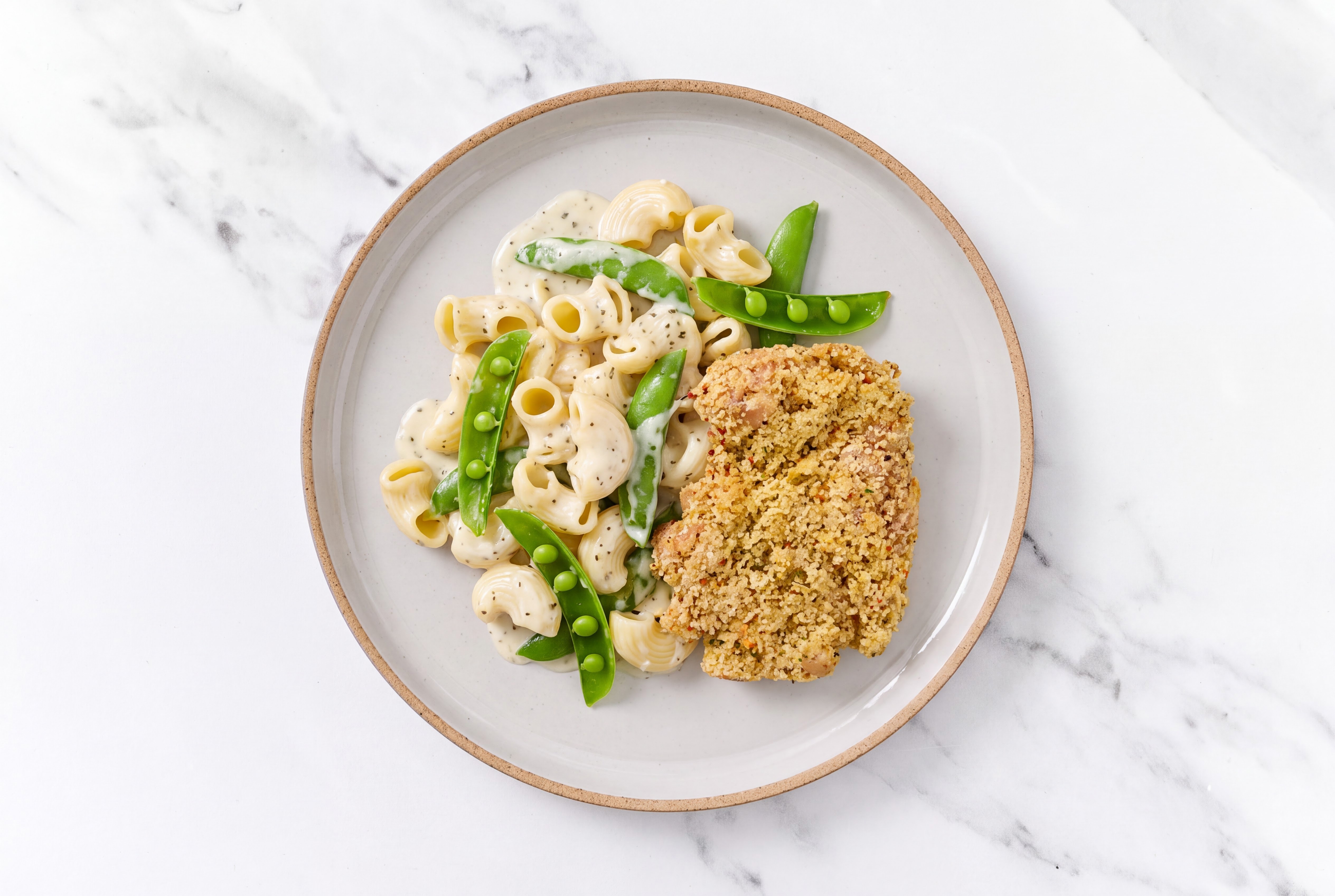 Crispy Garlic Chicken over Alfredo Chiocciole Pasta with Snap Peas