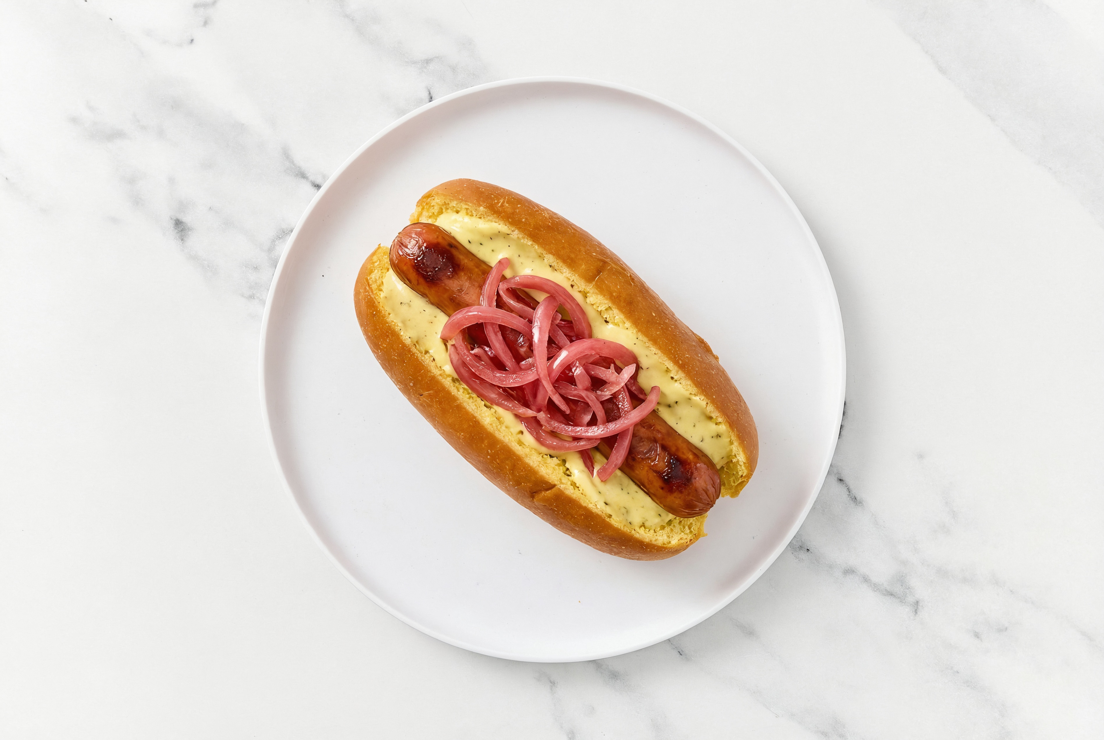 Pickled Red Onion Beef Hot Dog with Honey Musard Garlic Sauce on Brioche