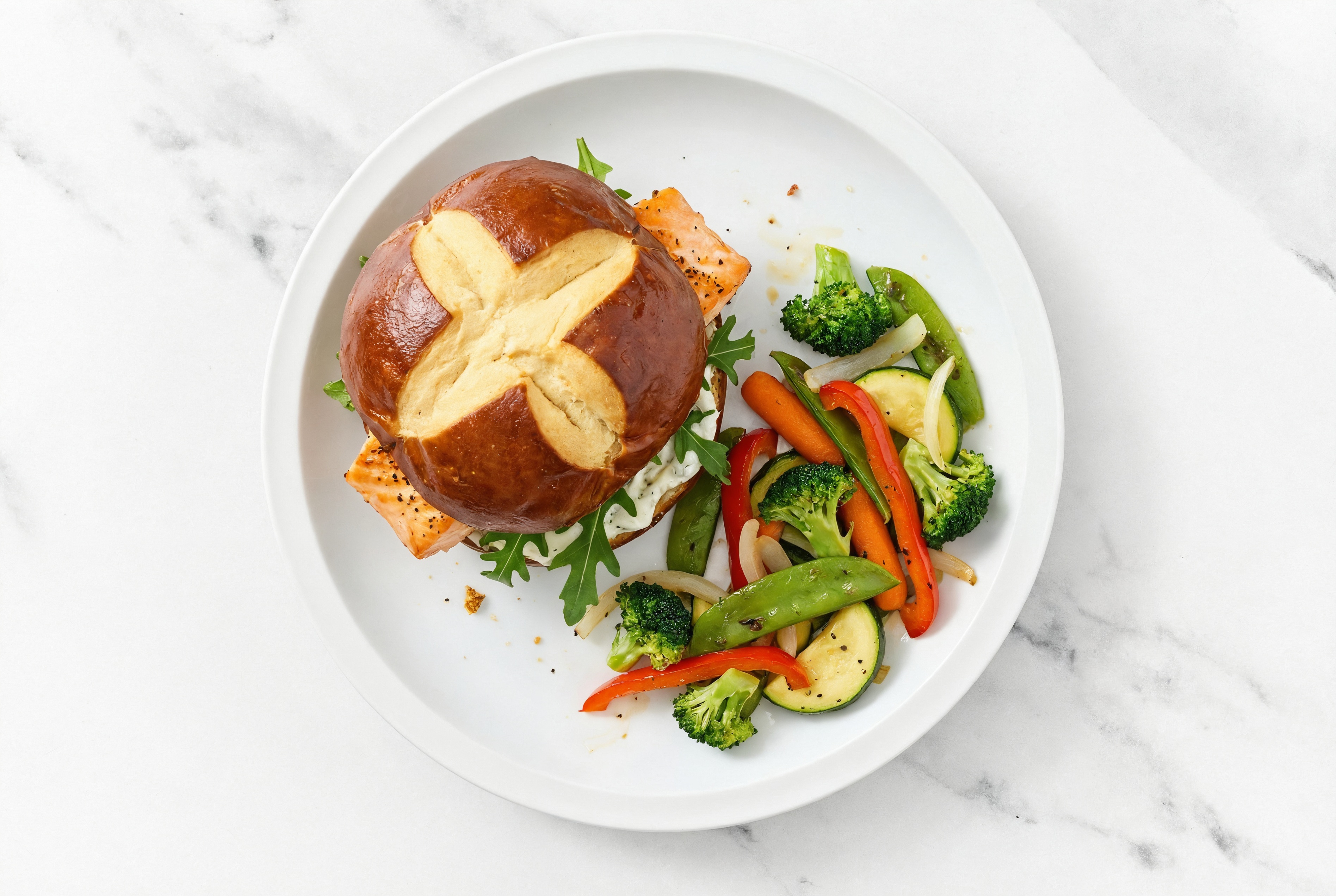 "Tzatziki" Salmon Sandwich on Pretzel Bun with Arugula + Mixed Veggies