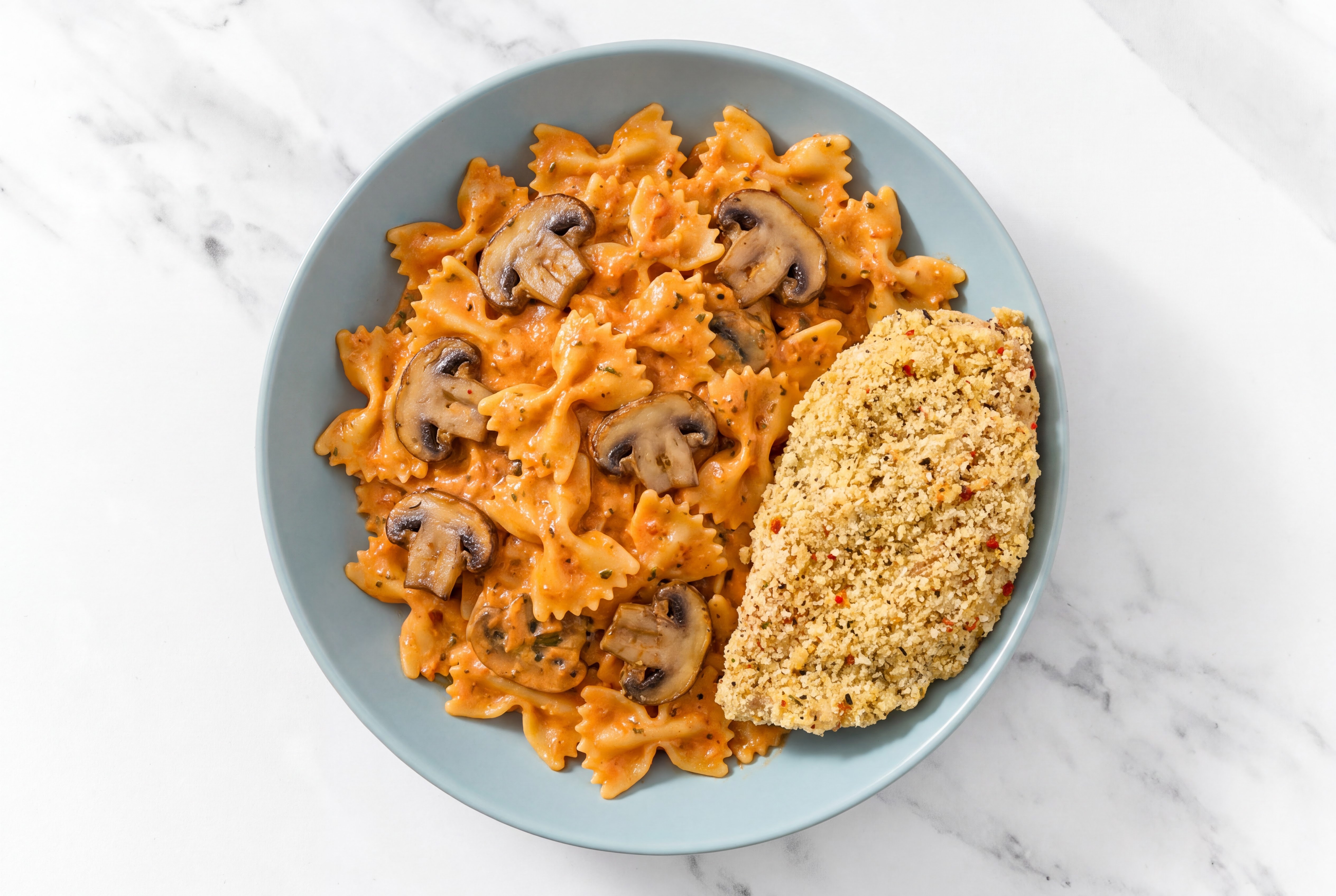 Crispy Garlic Chicken over Creamy Vodka Farfalle with Baby Bella Mushrooms
