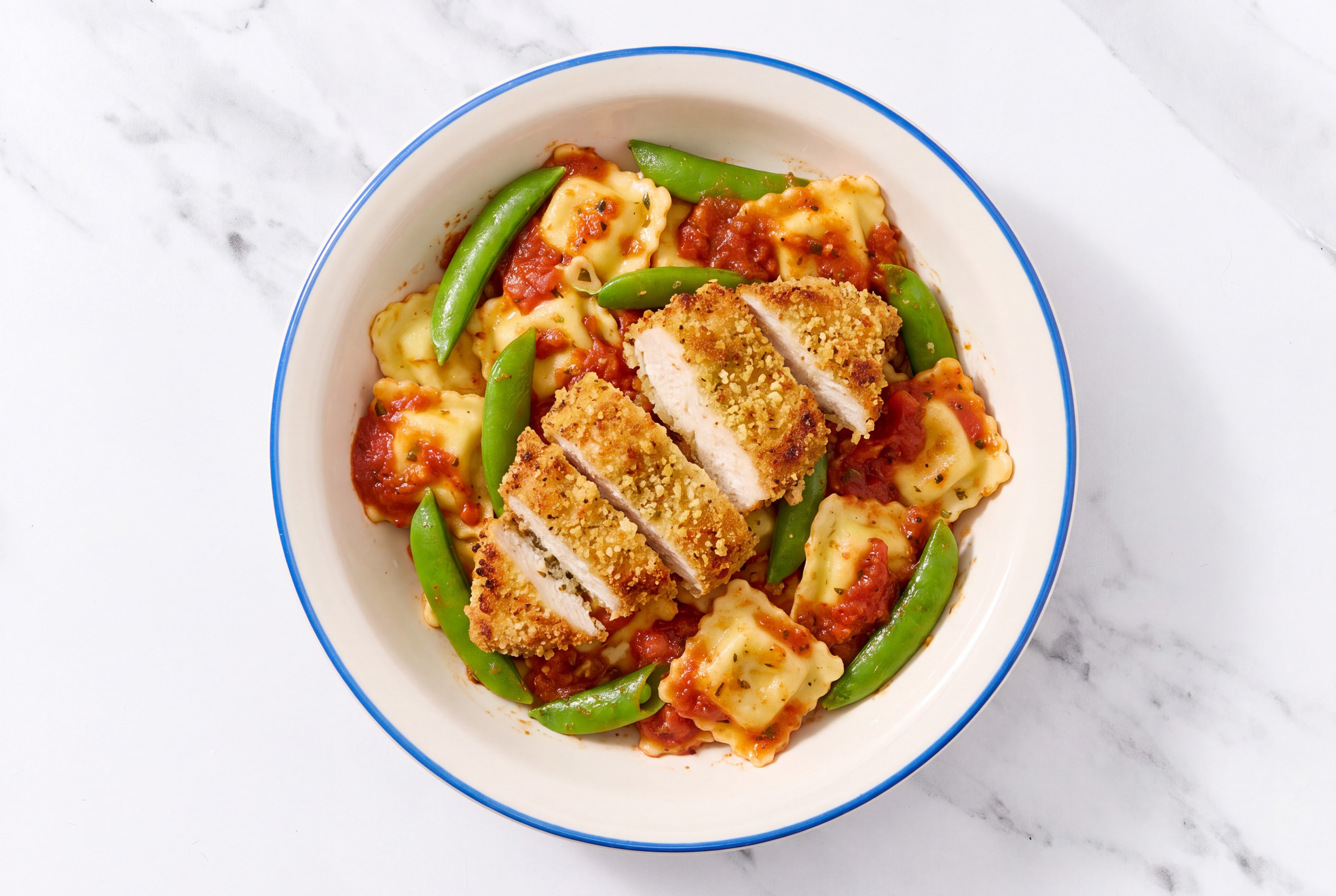 Crispy Garlic Chicken over Marinara Ravioli with Snap Peas