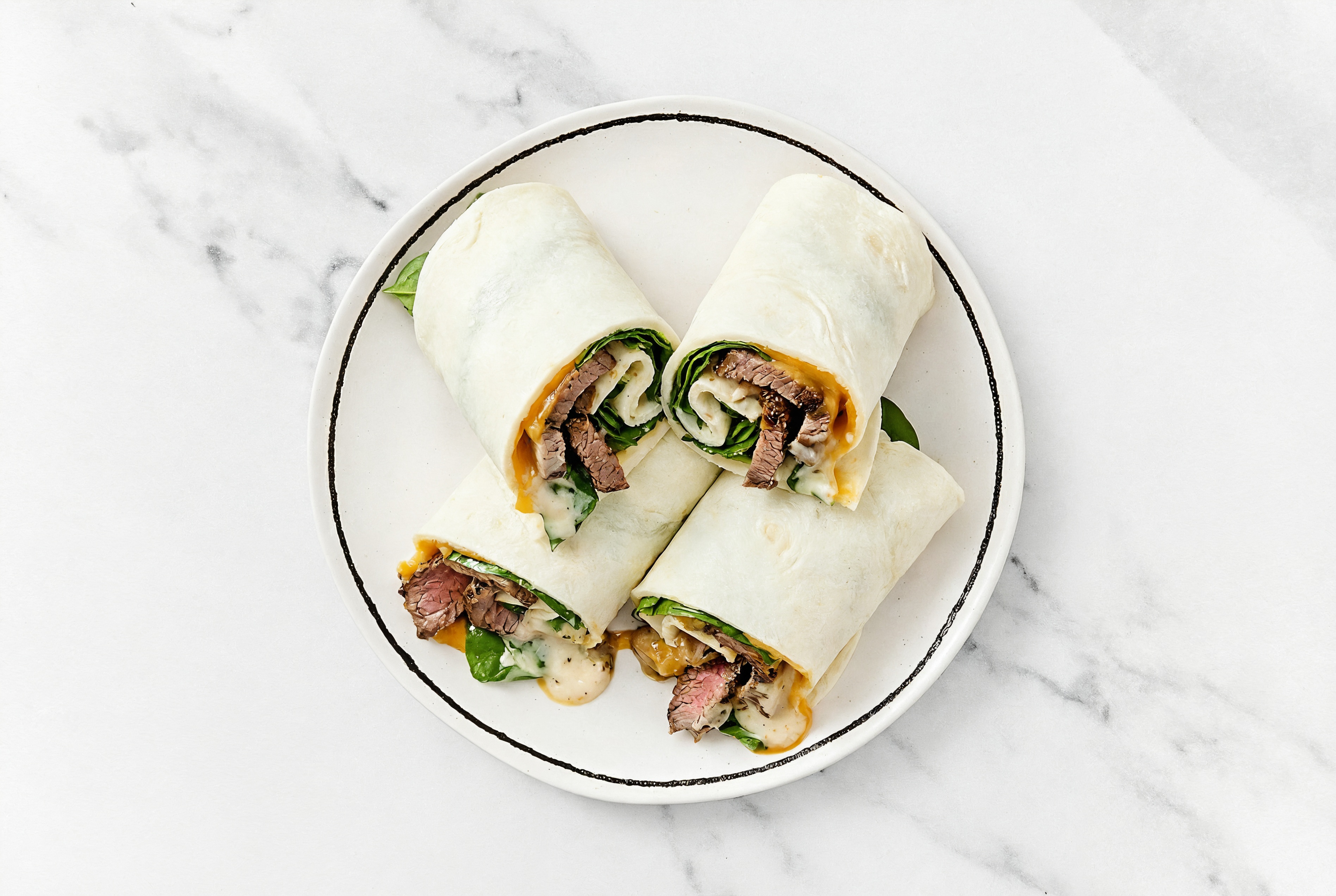 Garlic Sliced Steak + Cheddar Wraps with Spinach