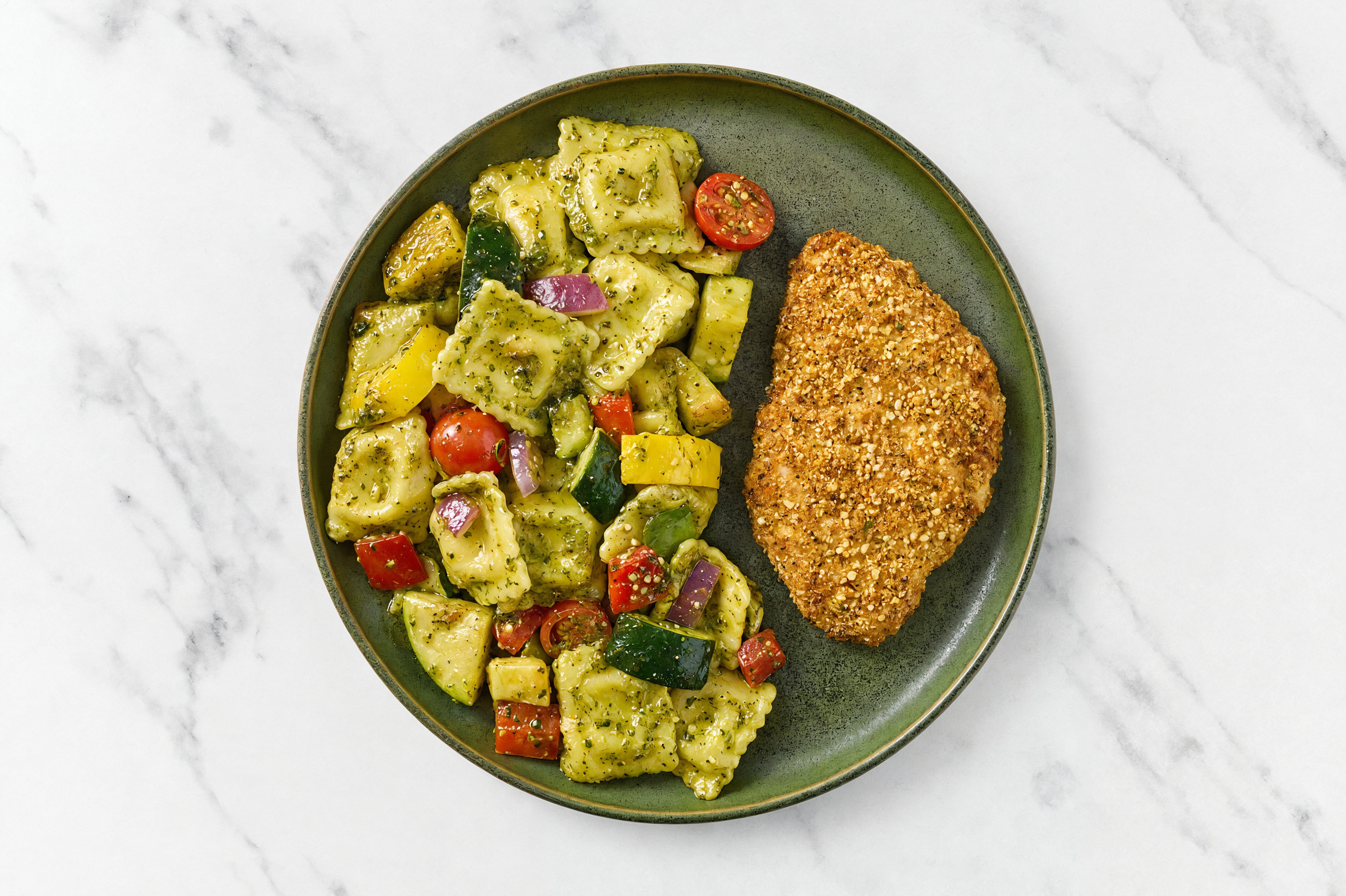 Crispy Garlic Chicken over Pesto Ravioli with Mixed Veggies