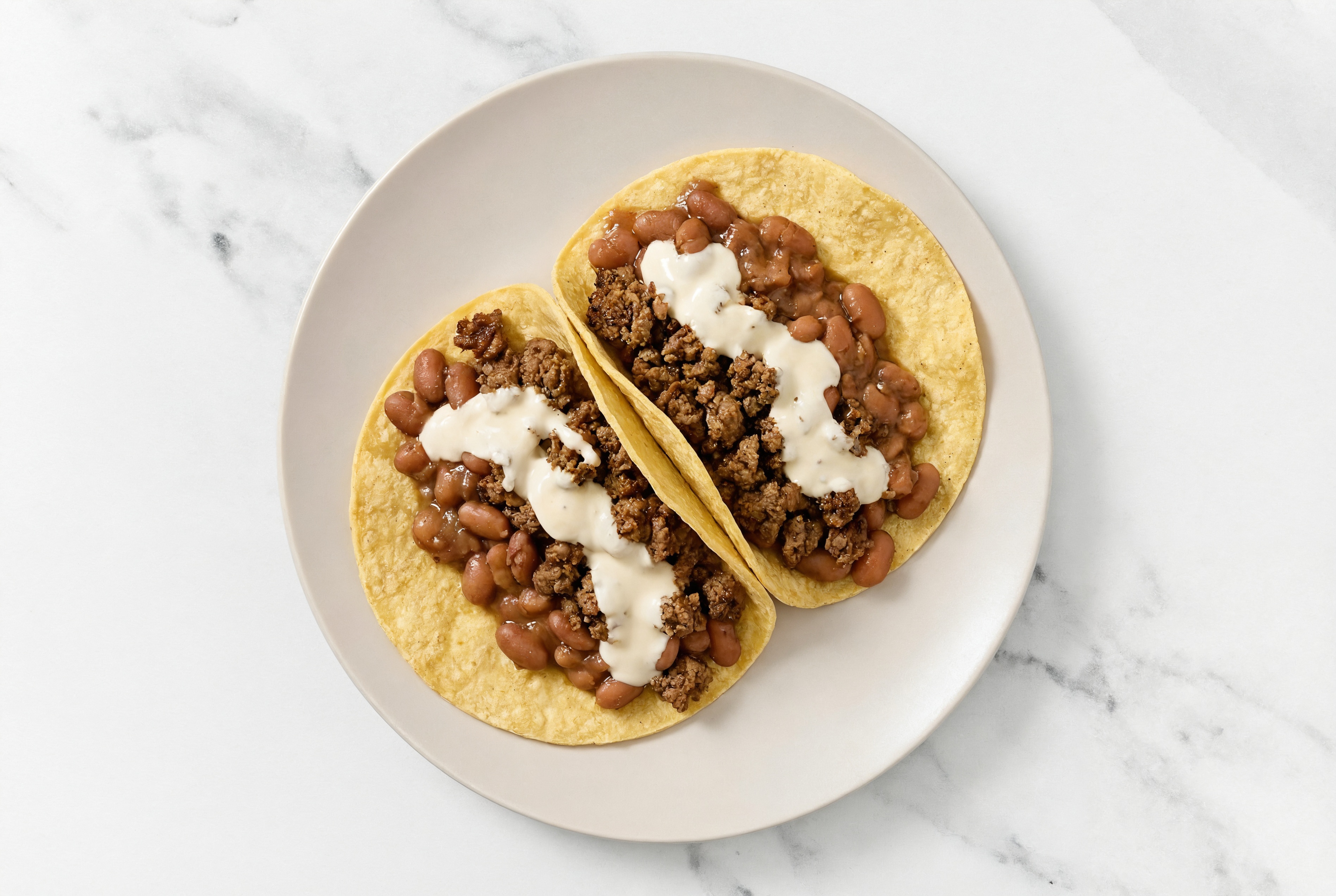 Herby Mexican-Style Ground Beef Tacos with Crema & Pinto Beans