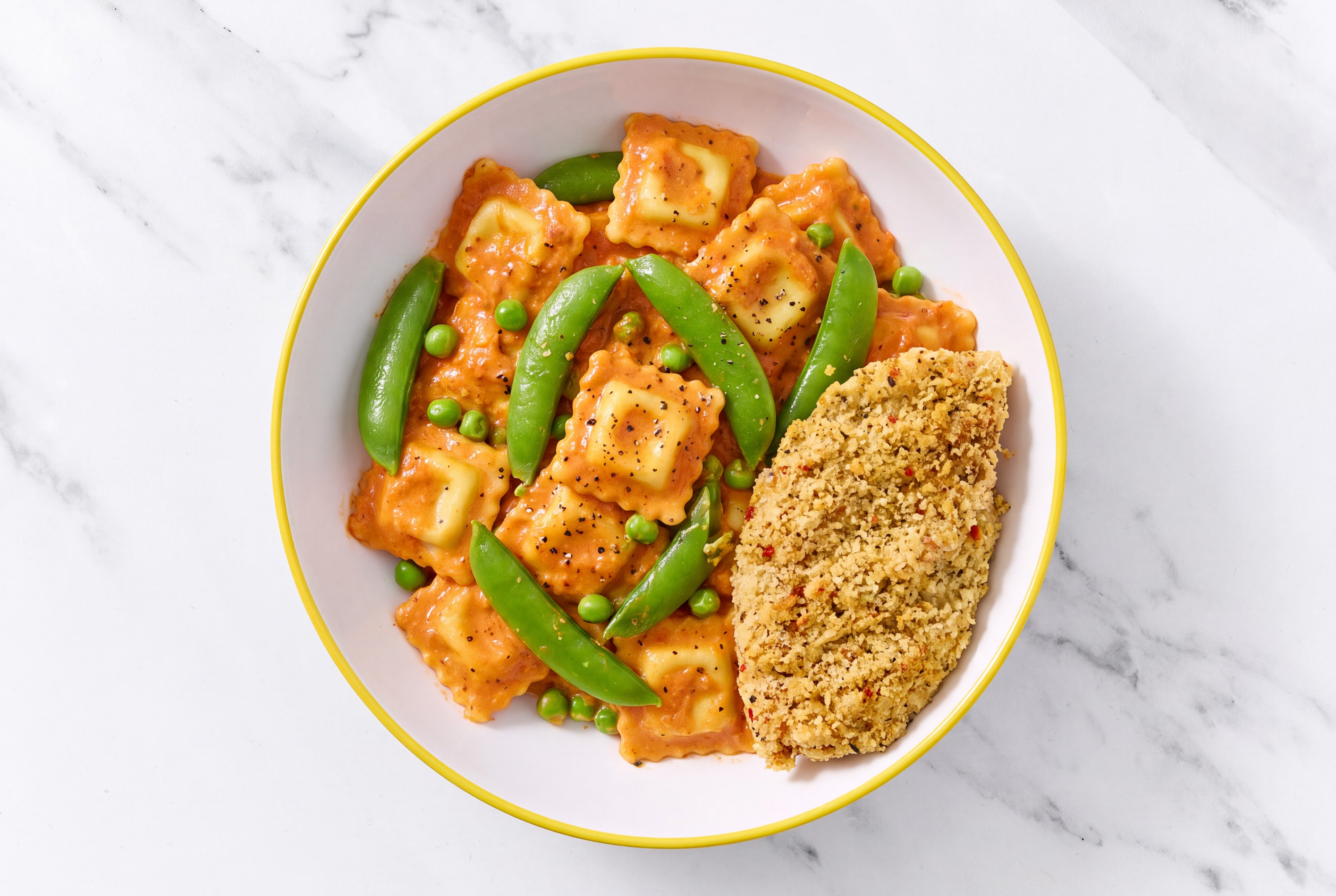 Crispy Garlic Chicken over Creamy Vodka Ravioli with Snap Peas