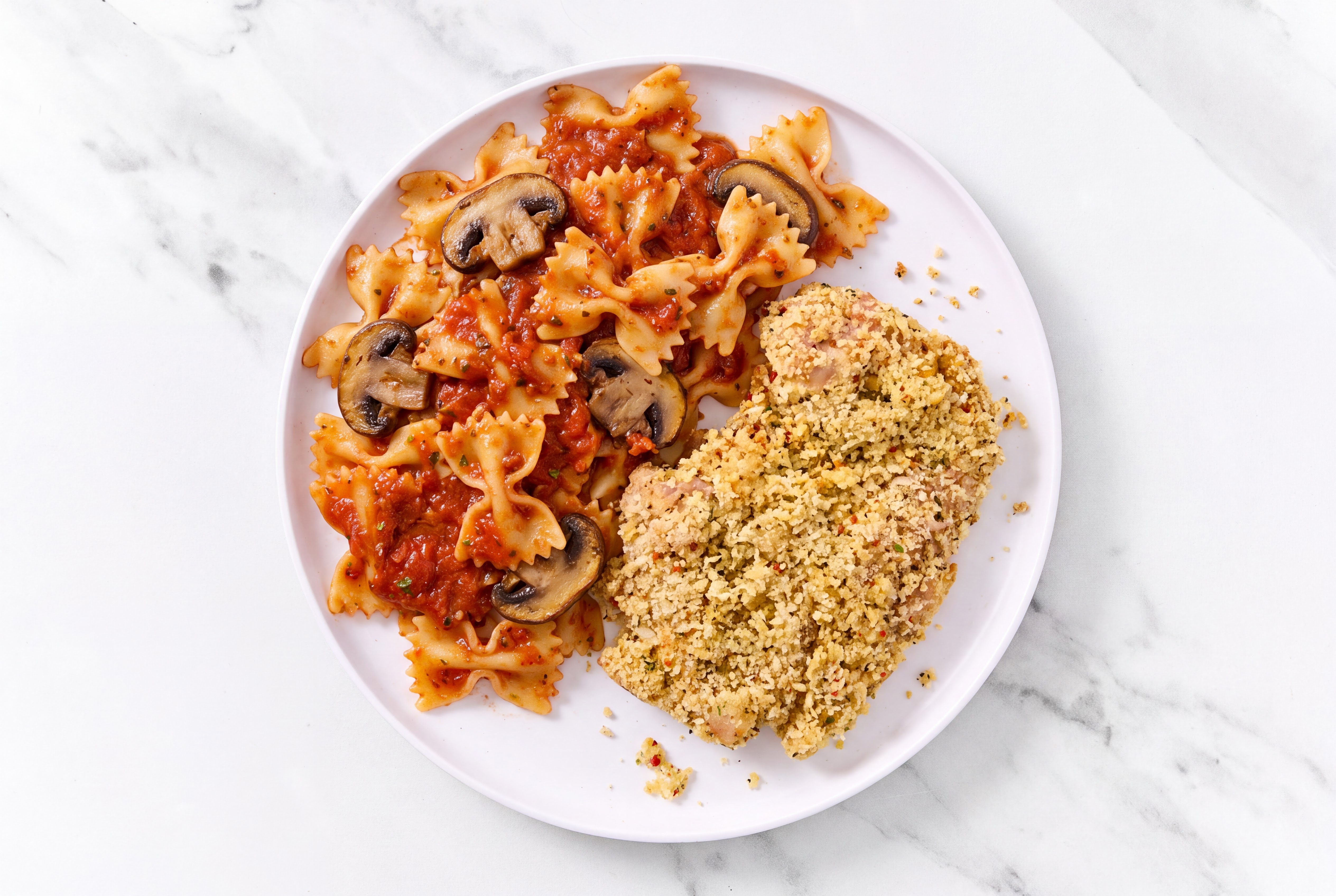 Crispy Garlic Chicken over Marinara Farfalle with Baby Bella Mushrooms
