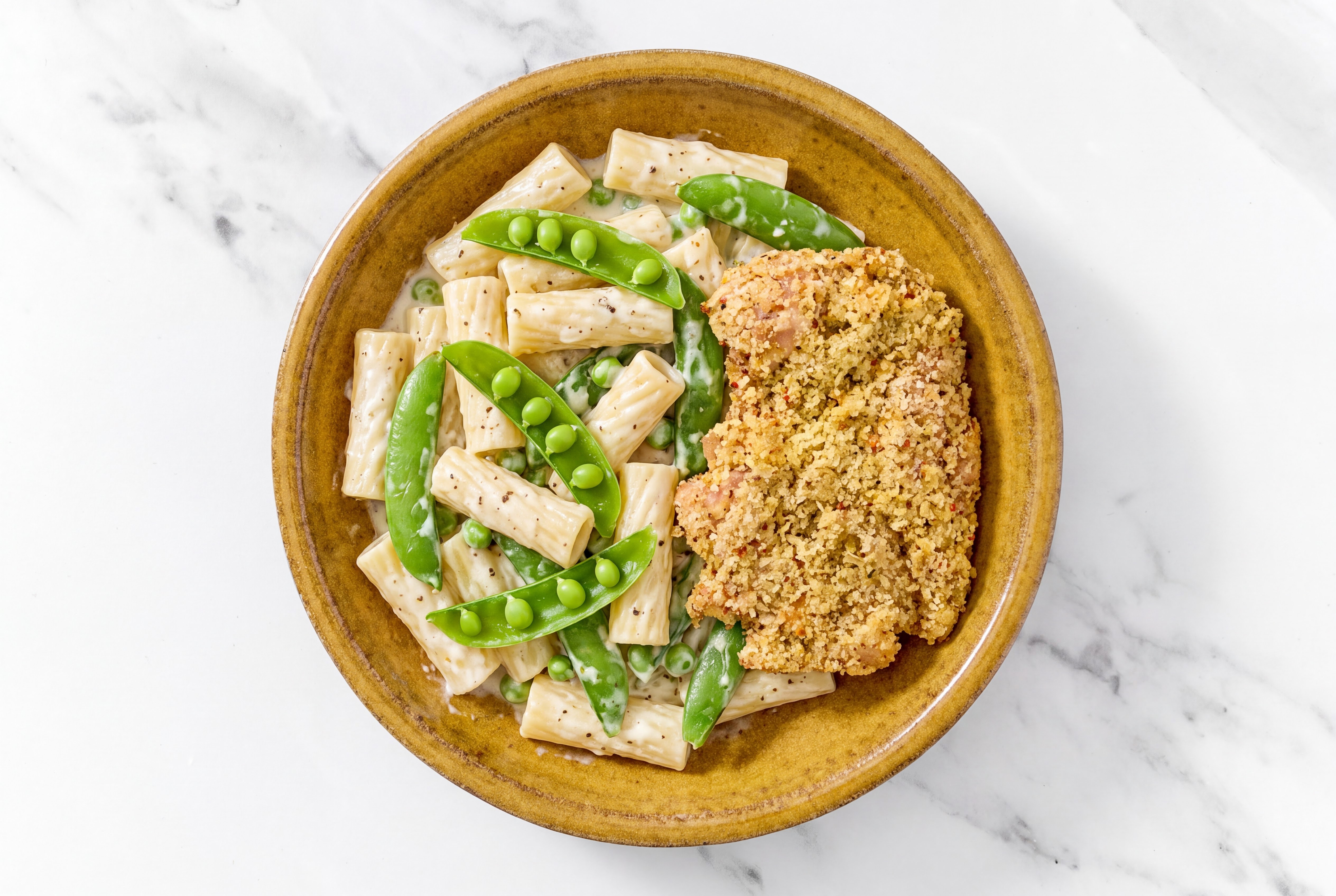 Crispy Garlic Chicken over Alfredo Rigatoni with Snap Peas