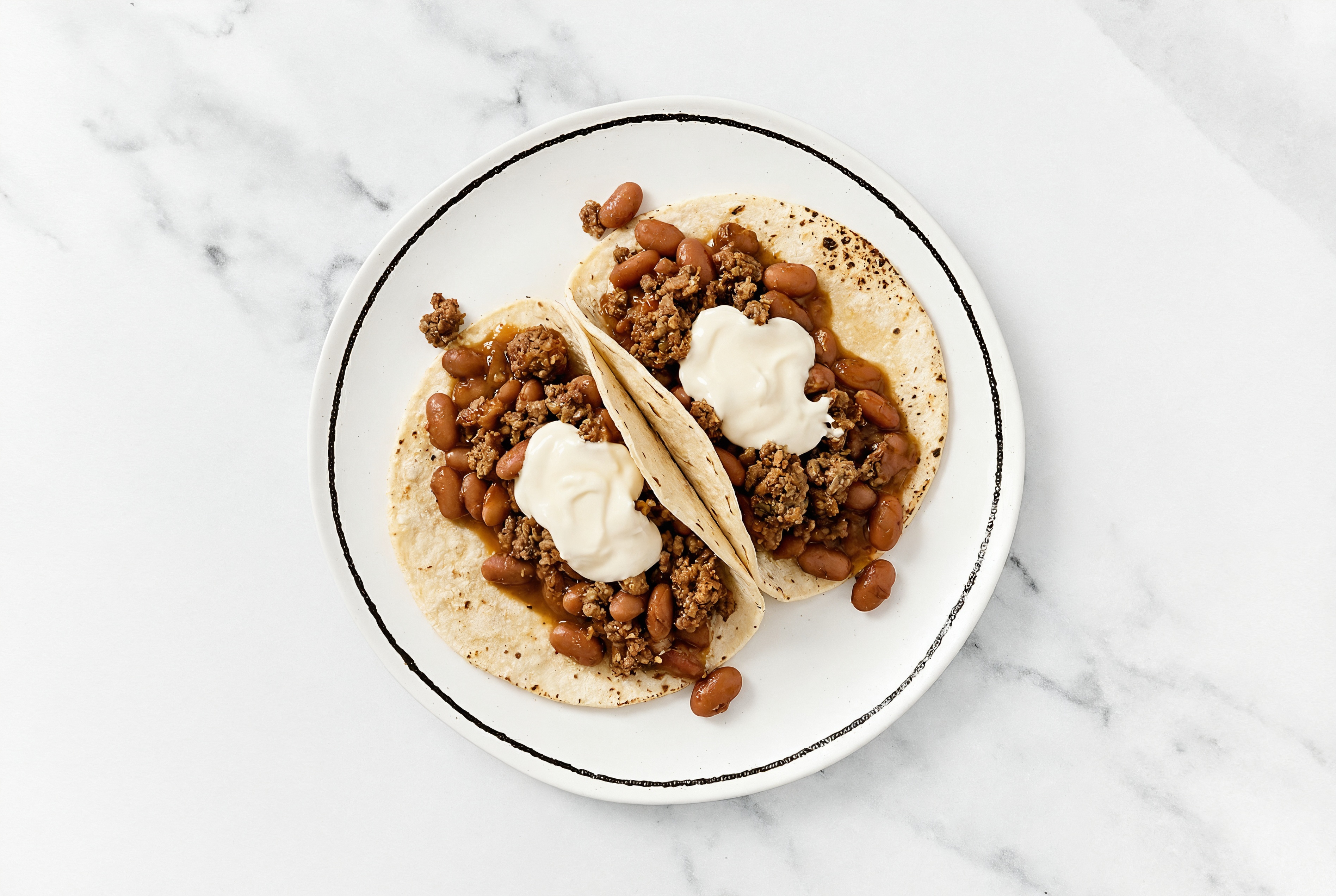 Hearty Mexican-Style Ground Beef Tacos with Crema & Pinto Beans