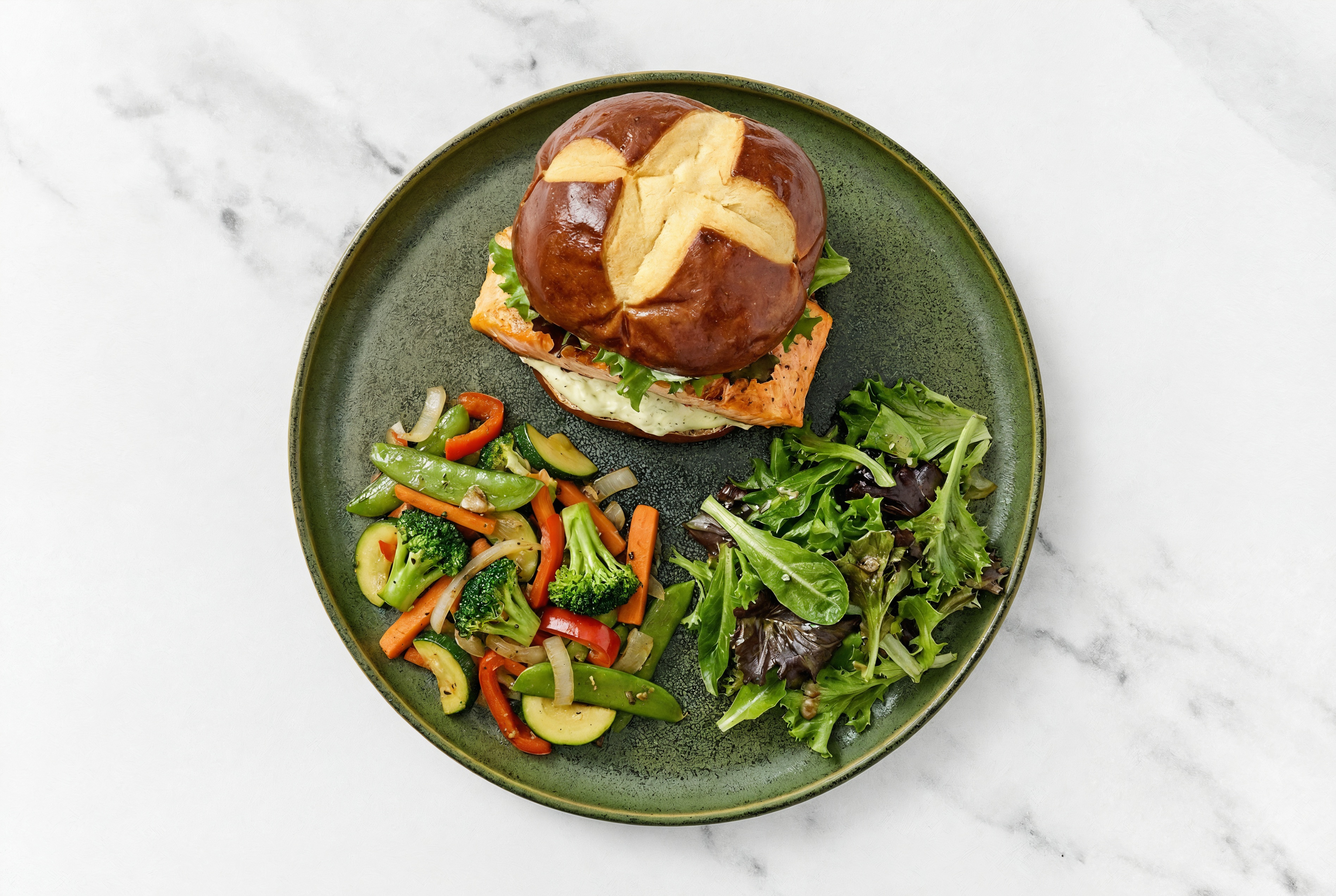Dill Pickle Salmon Sandwich on Pretzel Bun with Spring Mix + Mixed Veggies