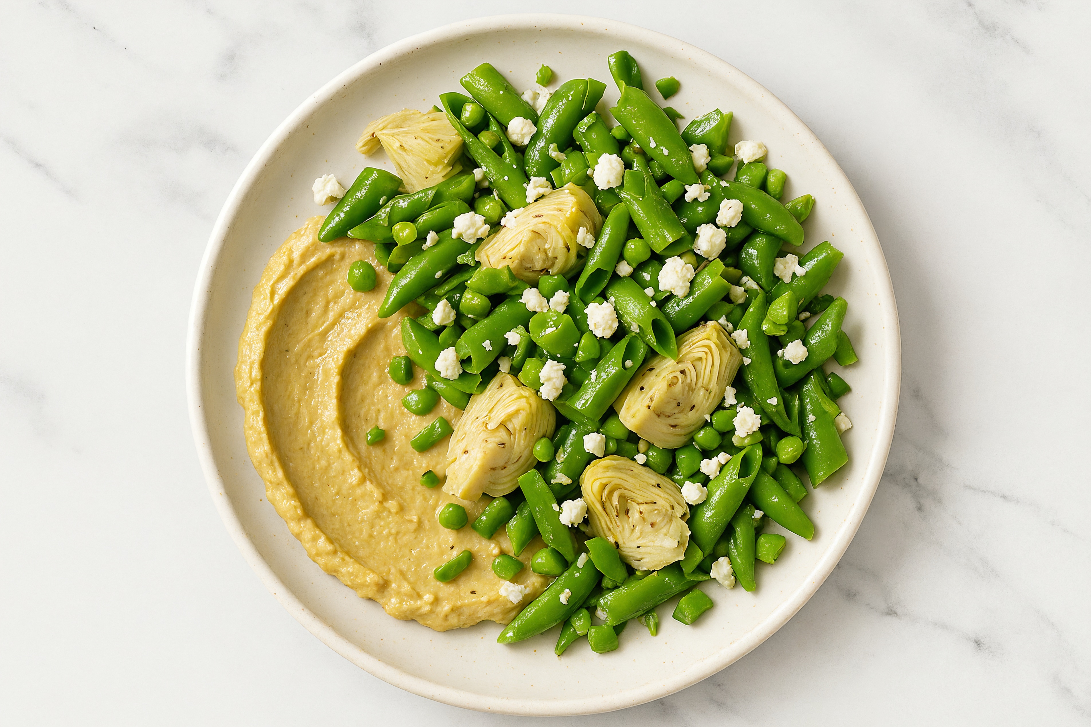 Crumbled Chevre Artichoke Snap Pea Bowl over Onion Hummus