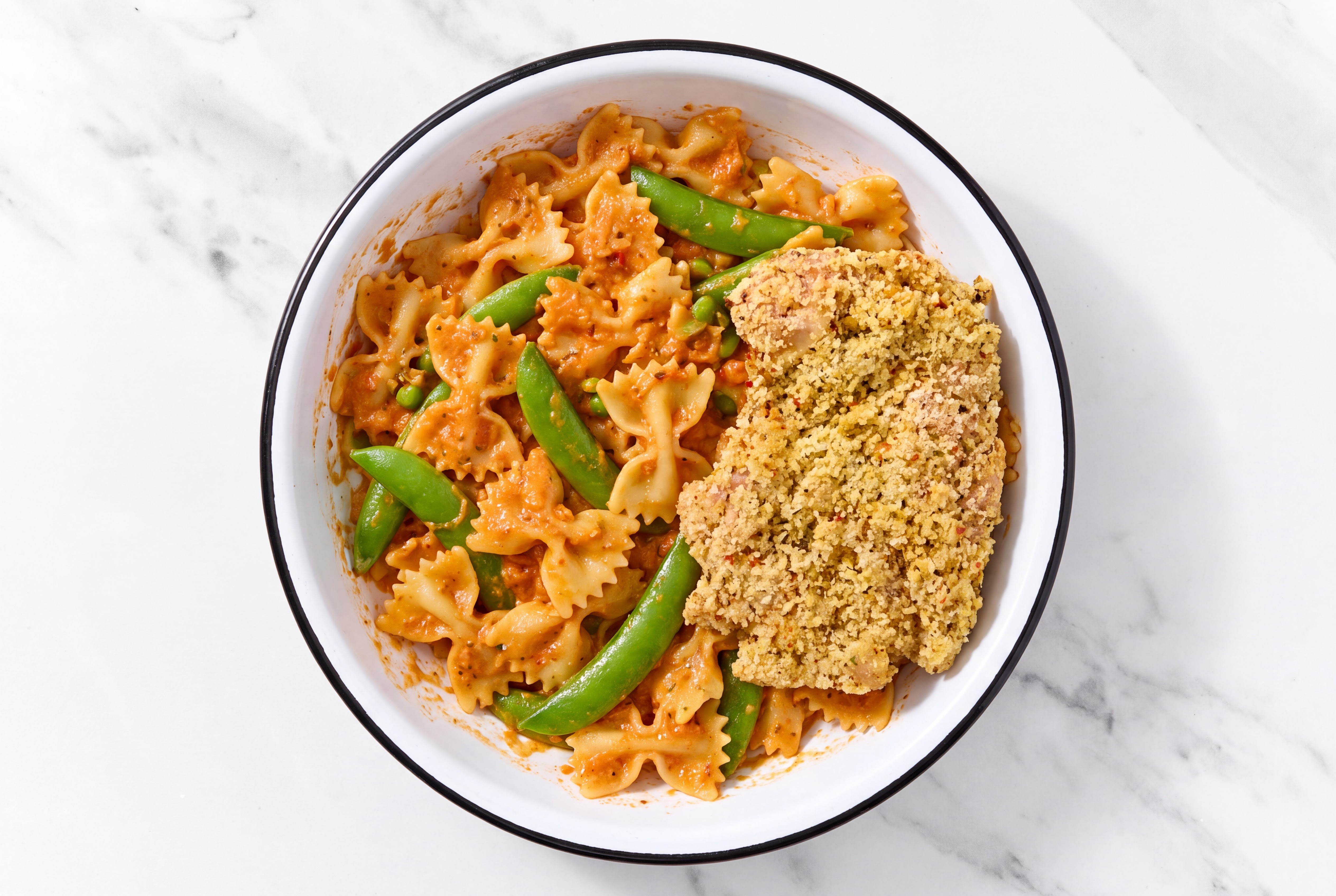 Crispy Garlic Chicken over Creamy Vodka Farfalle with Snap Peas