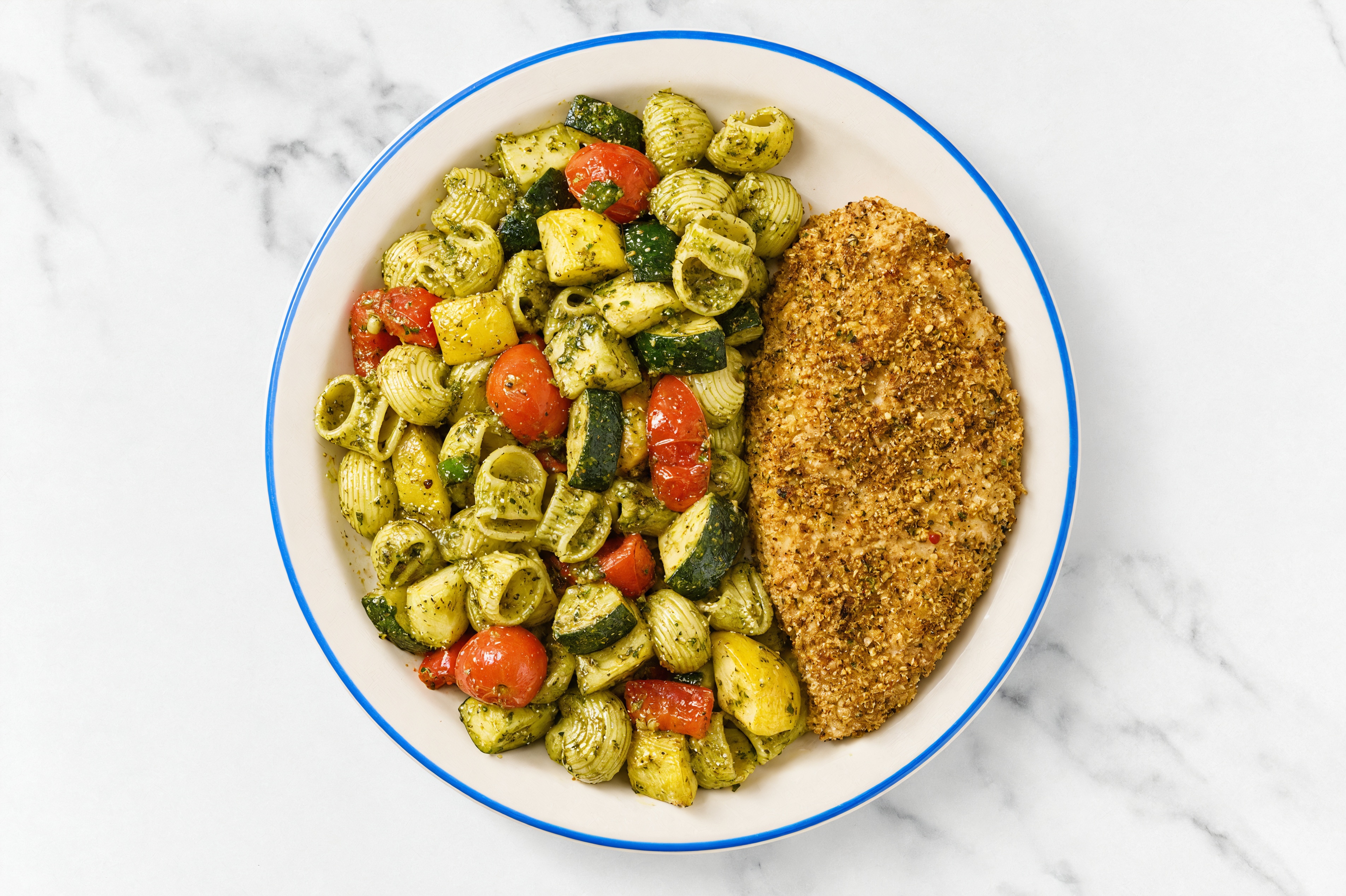 Crispy Garlic Chicken over Pesto Chiocciole Pasta with Mixed Veggies