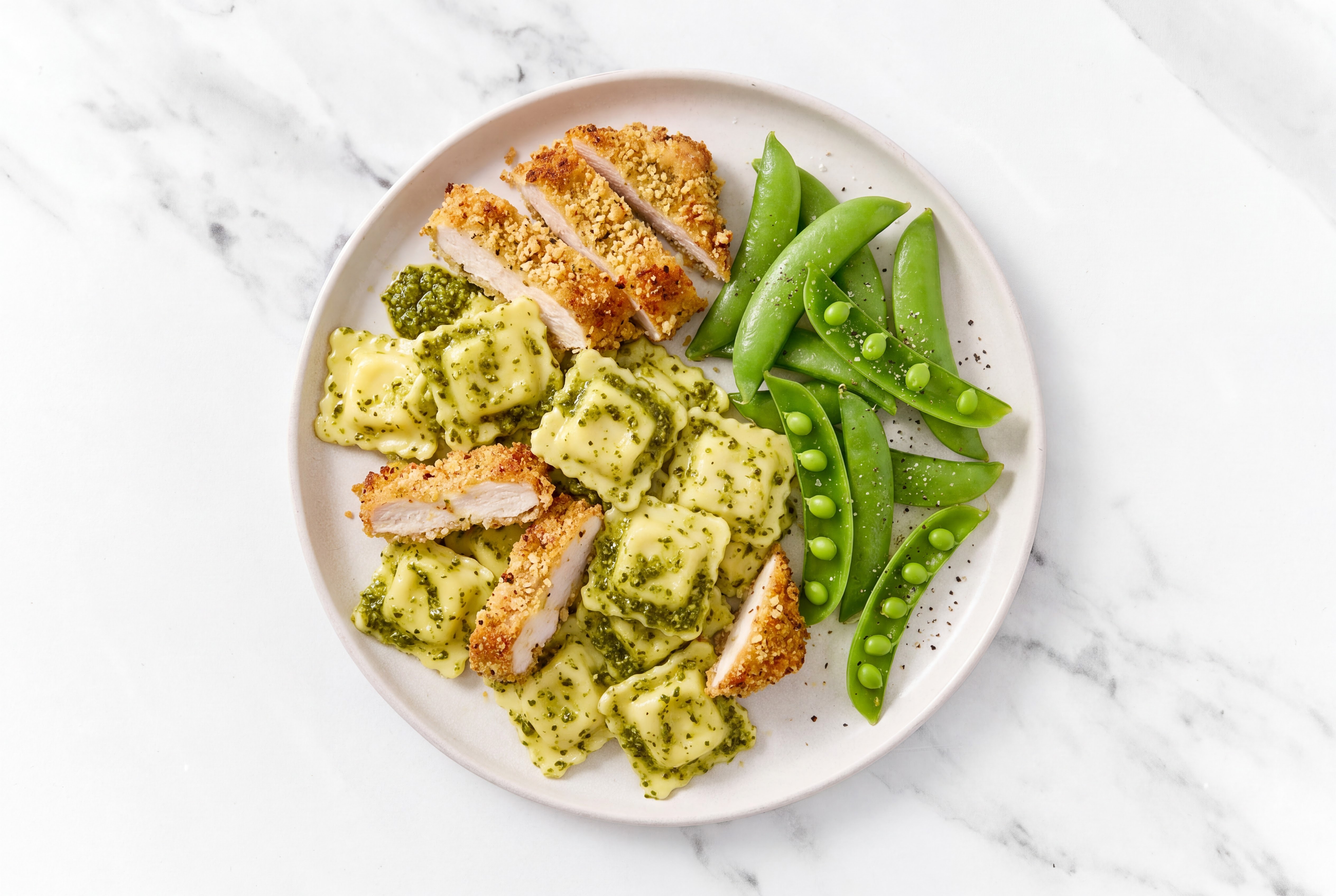 Crispy Garlic Chicken over Pesto Ravioli with Snap Peas