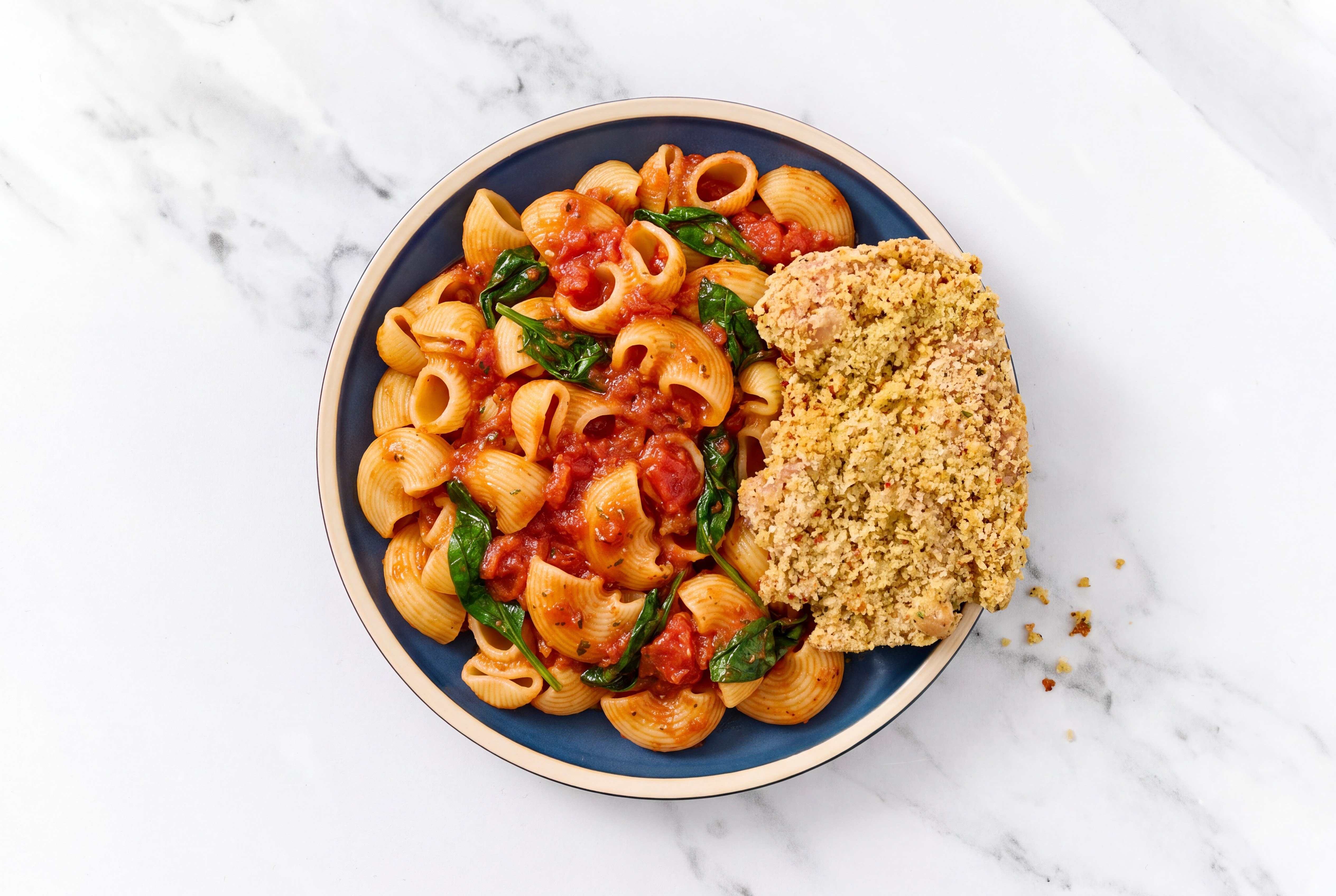 Crispy Garlic Chicken over Marinara Chiocciole Pasta with Baby Spinach