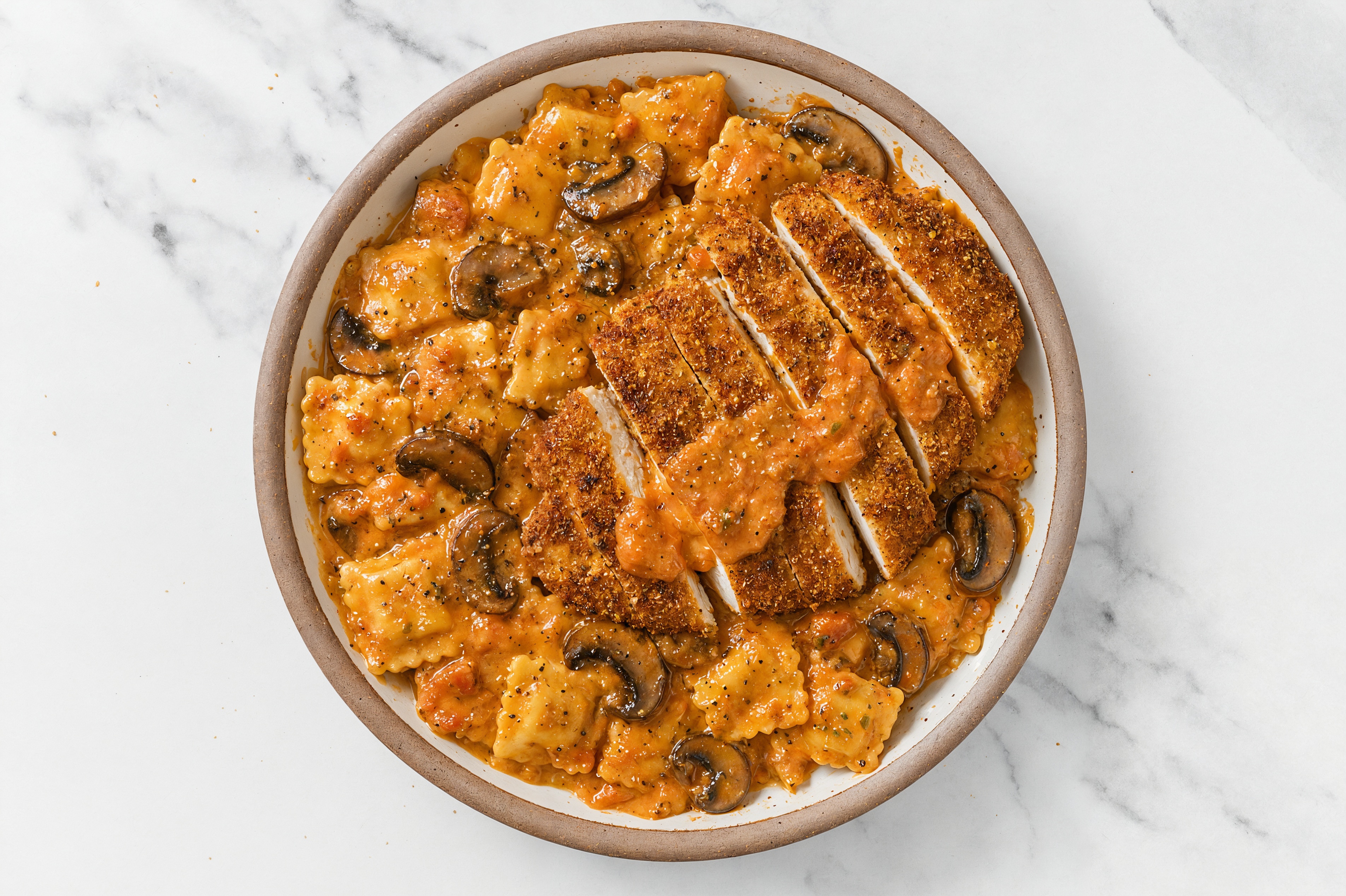 Crispy Garlic Chicken over Creamy Vodka Ravioli with Baby Bella Mushrooms