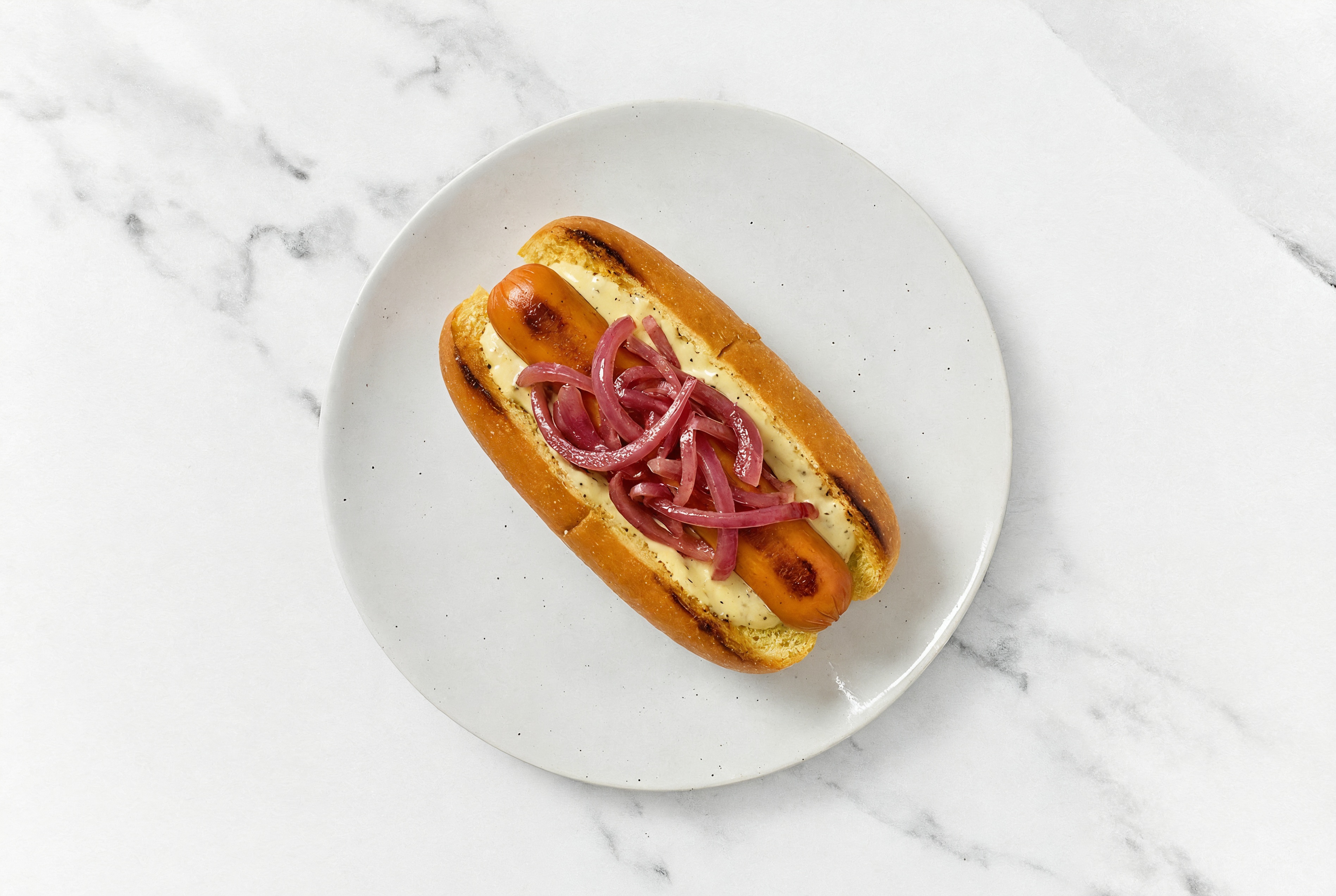 Pickled Red Onion Smart Dog with Honey Musard Garlic Sauce on Brioche