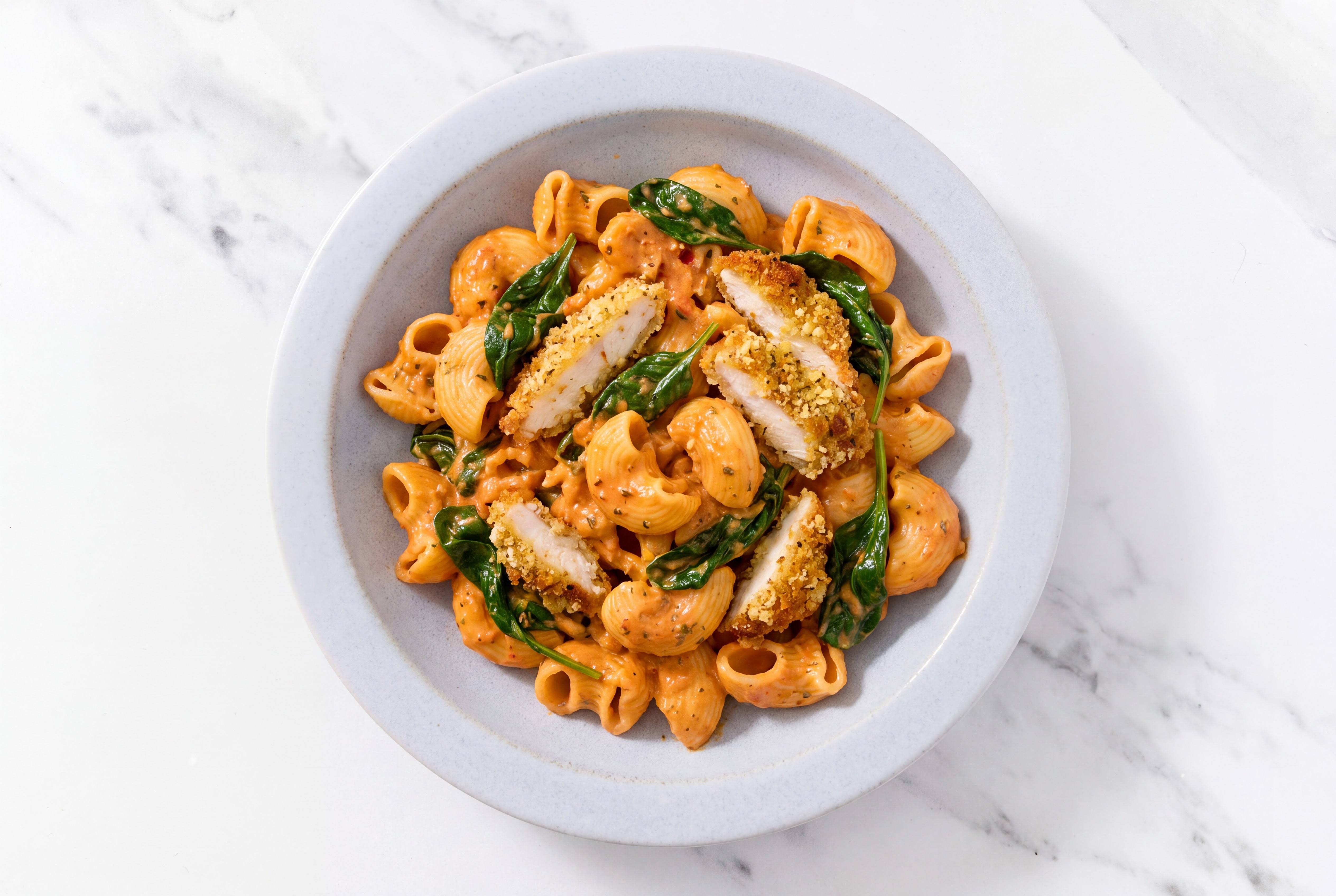 Crispy Garlic Chicken over Creamy Vodka Chiocciole Pasta with Baby Spinach