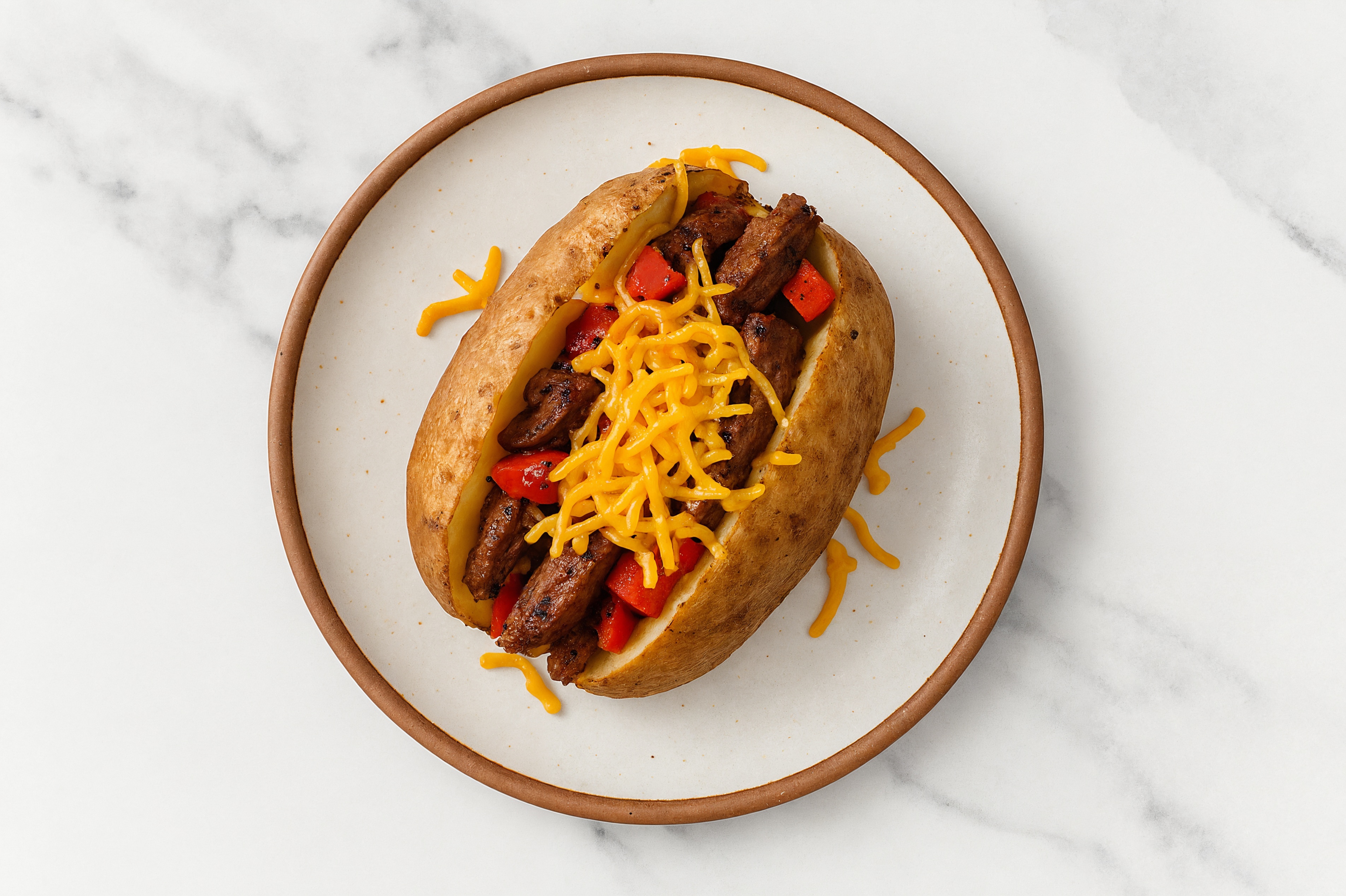 Steak + Pepper Loaded Baked Potato with Shredded Sharp Cheddar Cheese