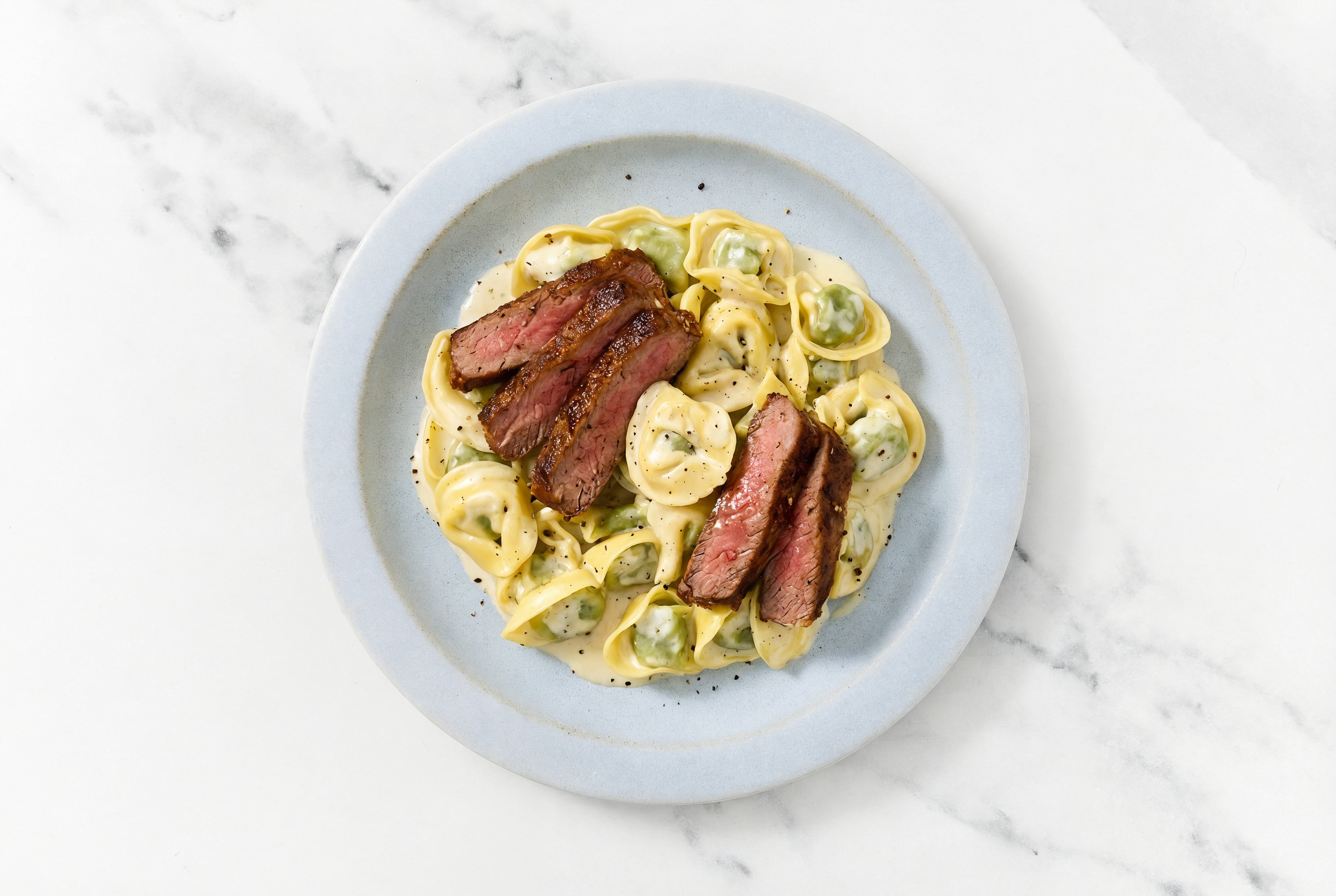 Steakhouse Cheese Tortellini Alfredo with Adobo Marinated Flank Steak
