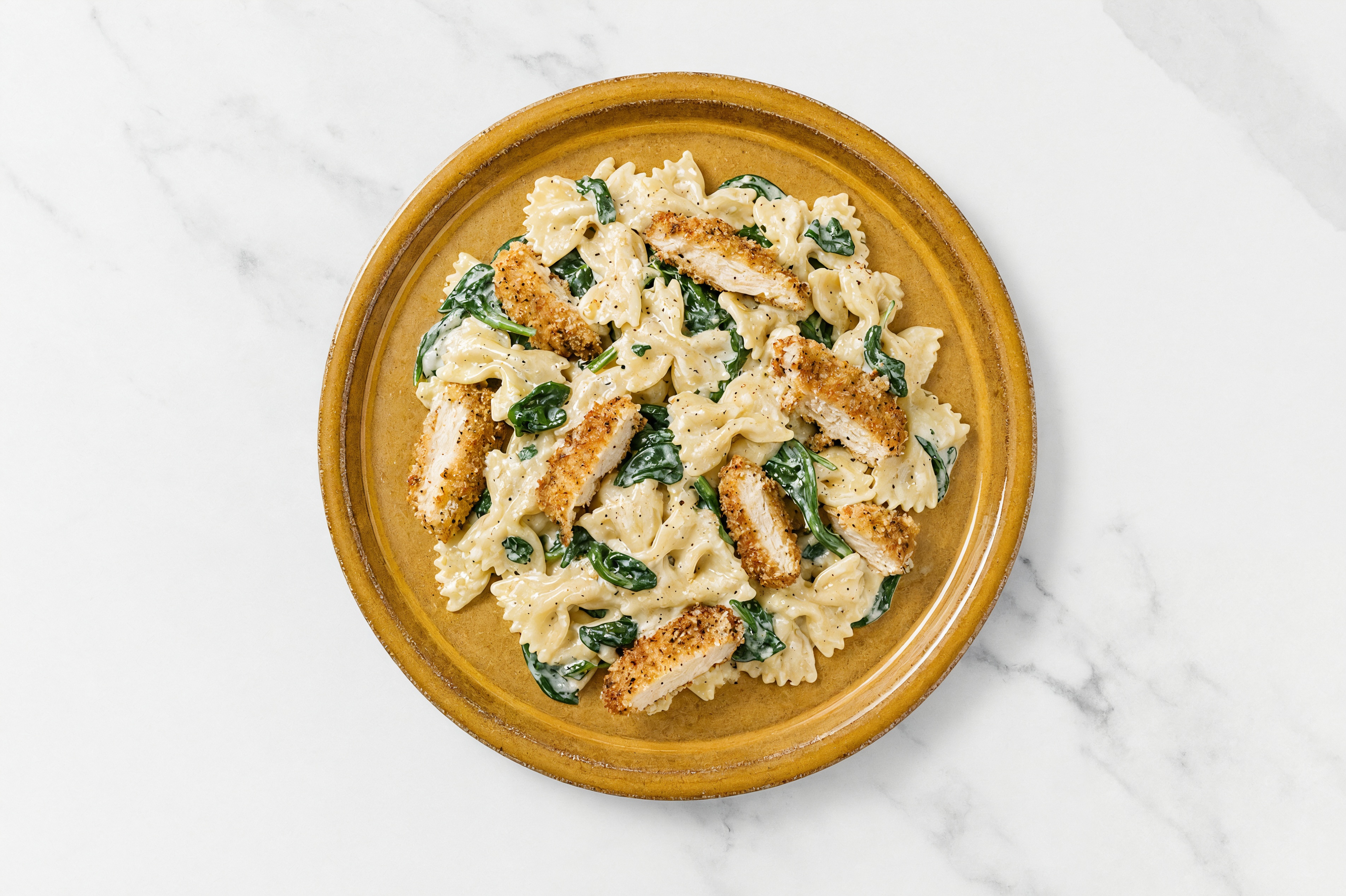 Crispy Garlic Chicken over Alfredo Farfalle with Baby Spinach