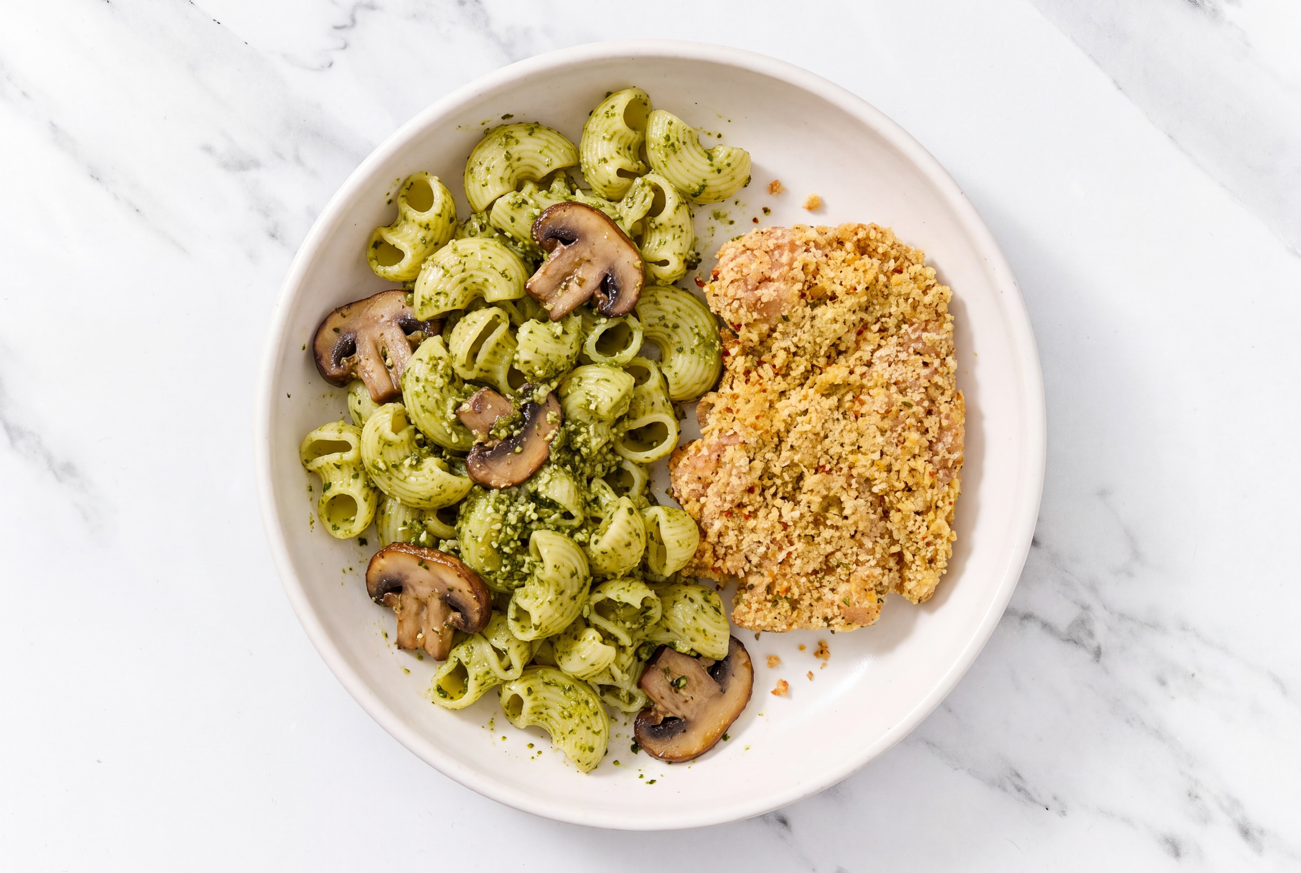 Crispy Garlic Chicken over Pesto Chiocciole Pasta with Baby Bella Mushrooms