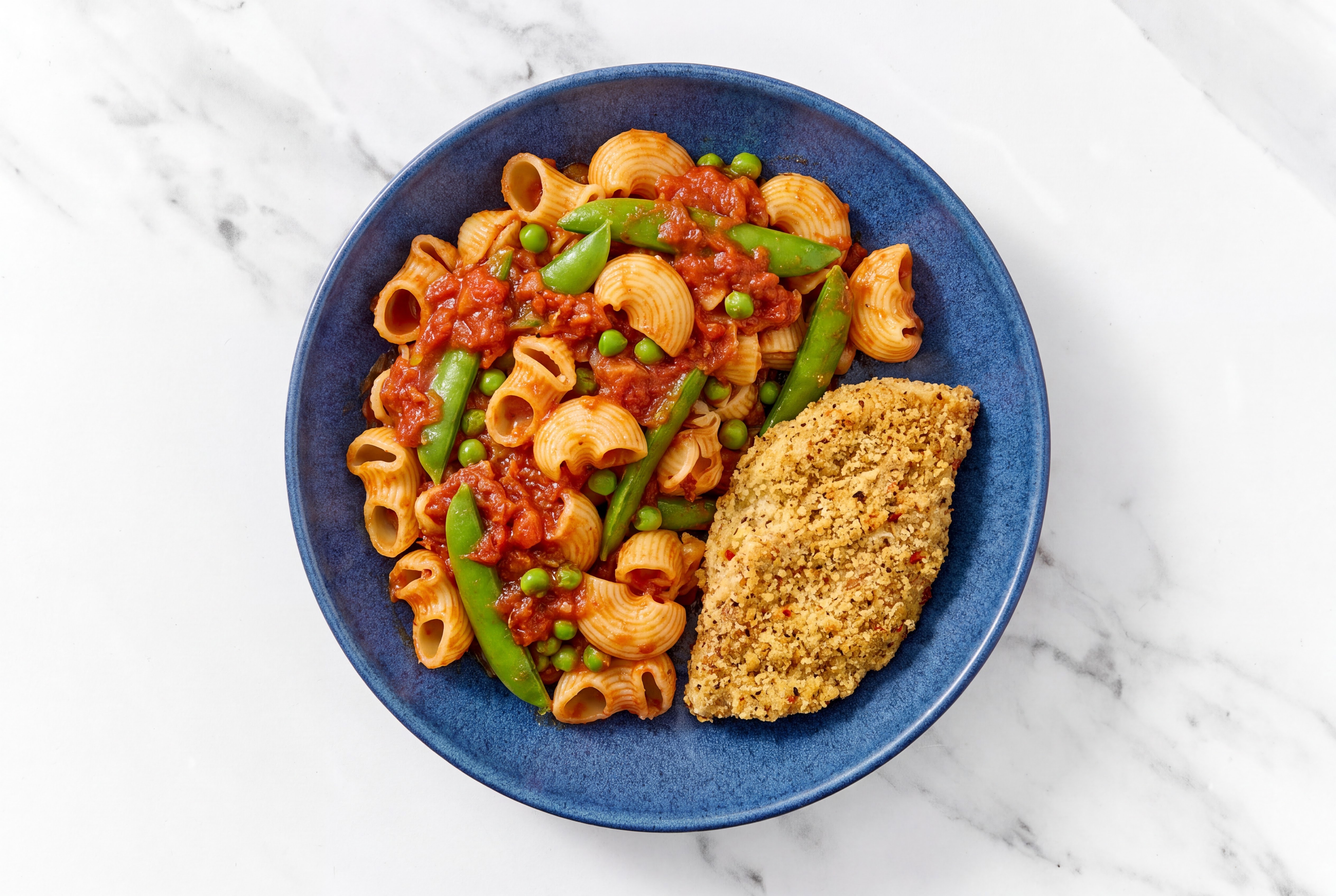 Crispy Garlic Chicken over Marinara Chiocciole Pasta with Snap Peas