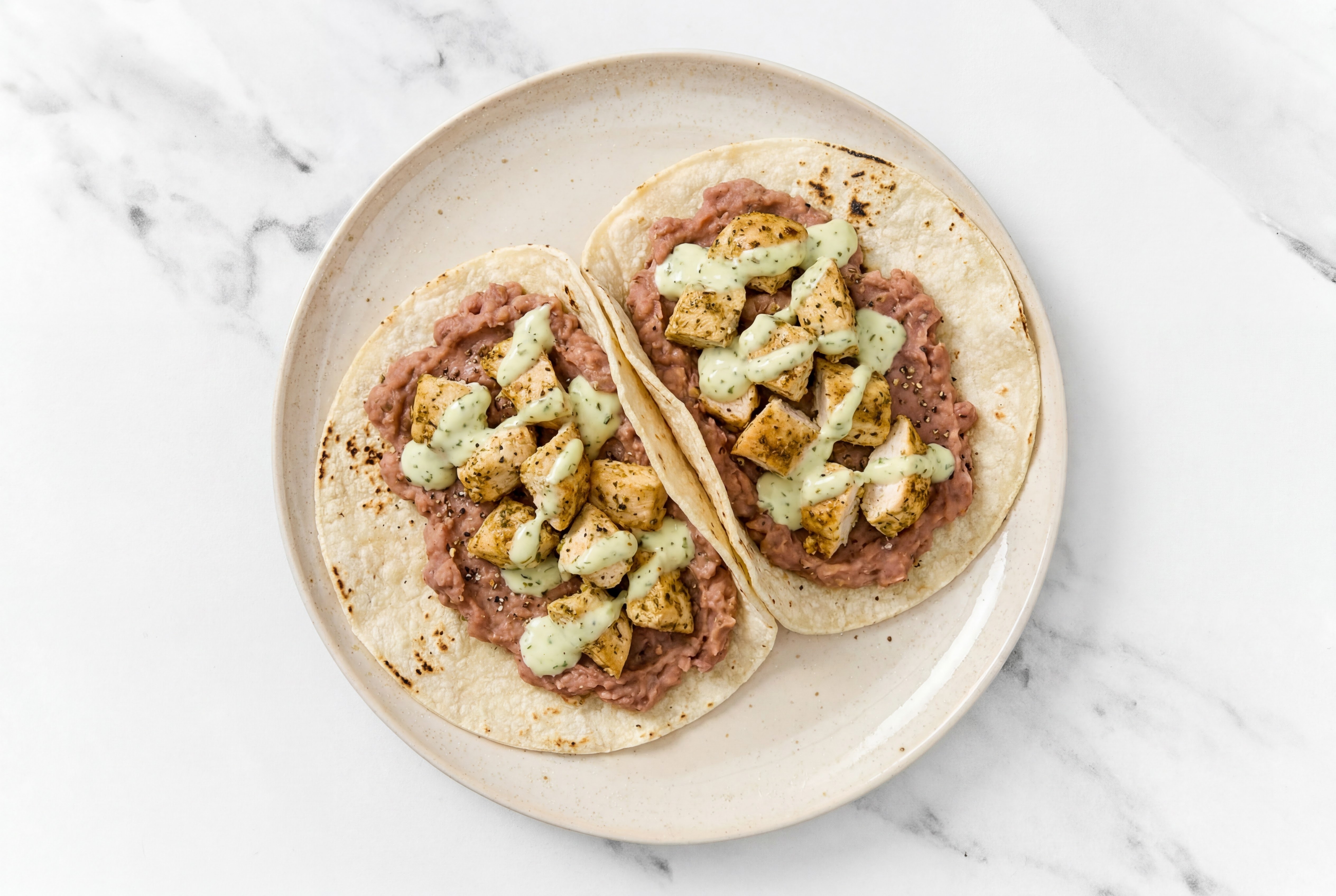 Hearty Garlic Chicken Tacos with Jalapeño Crema & Refried Red Beans