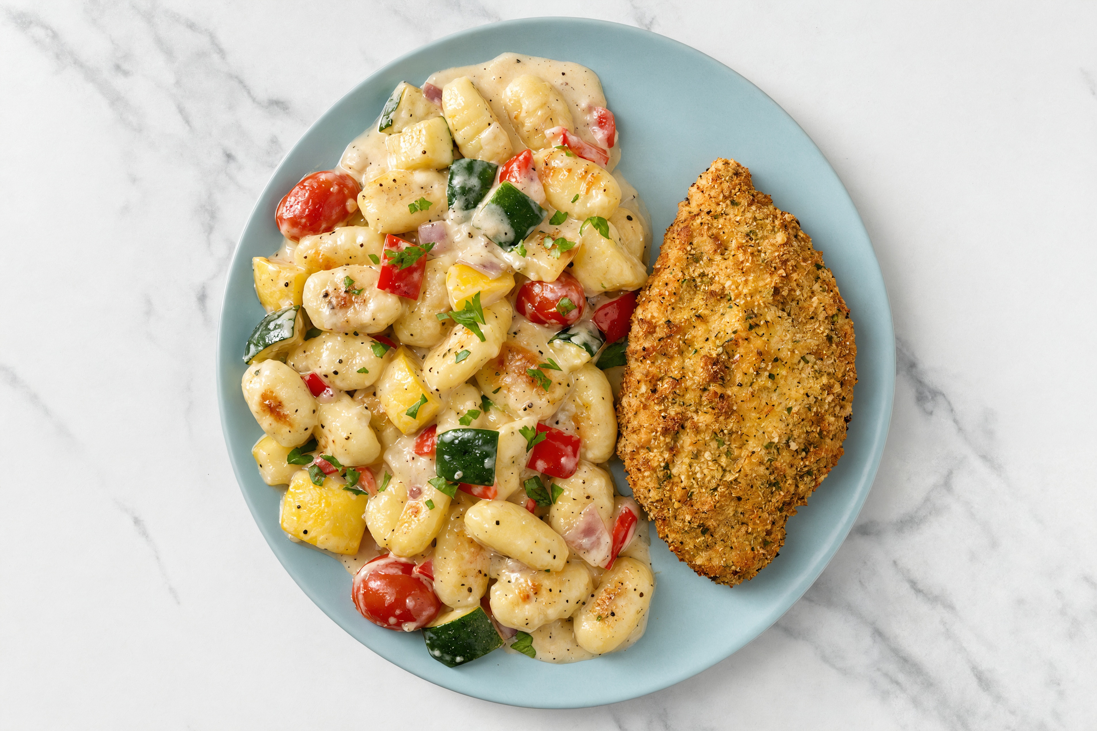 Crispy Garlic Chicken over Alfredo Gnocchi with Mixed Veggies