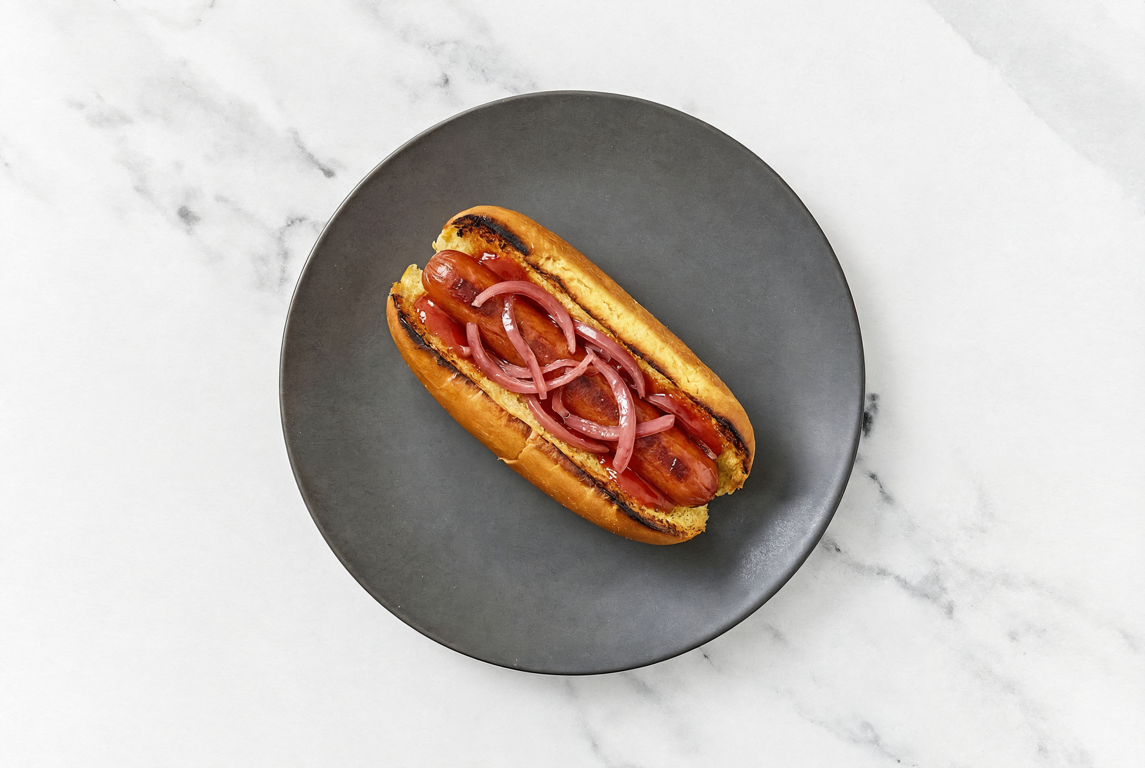 Pickled Red Onion Beef Hot Dog with Ketchup on Brioche