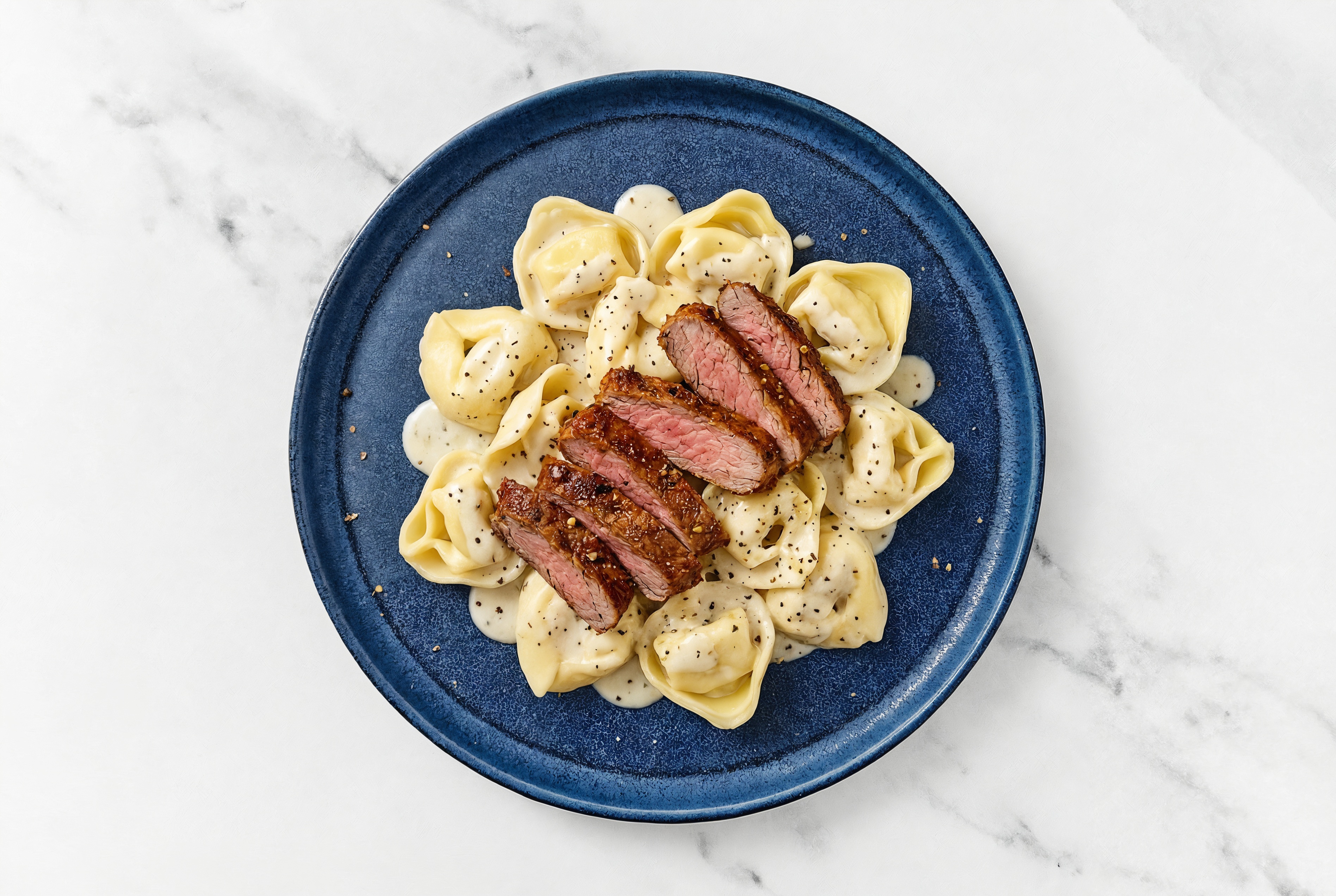 Steakhouse Cheese Tortelloni Alfredo with Adobo Marinated Flank Steak