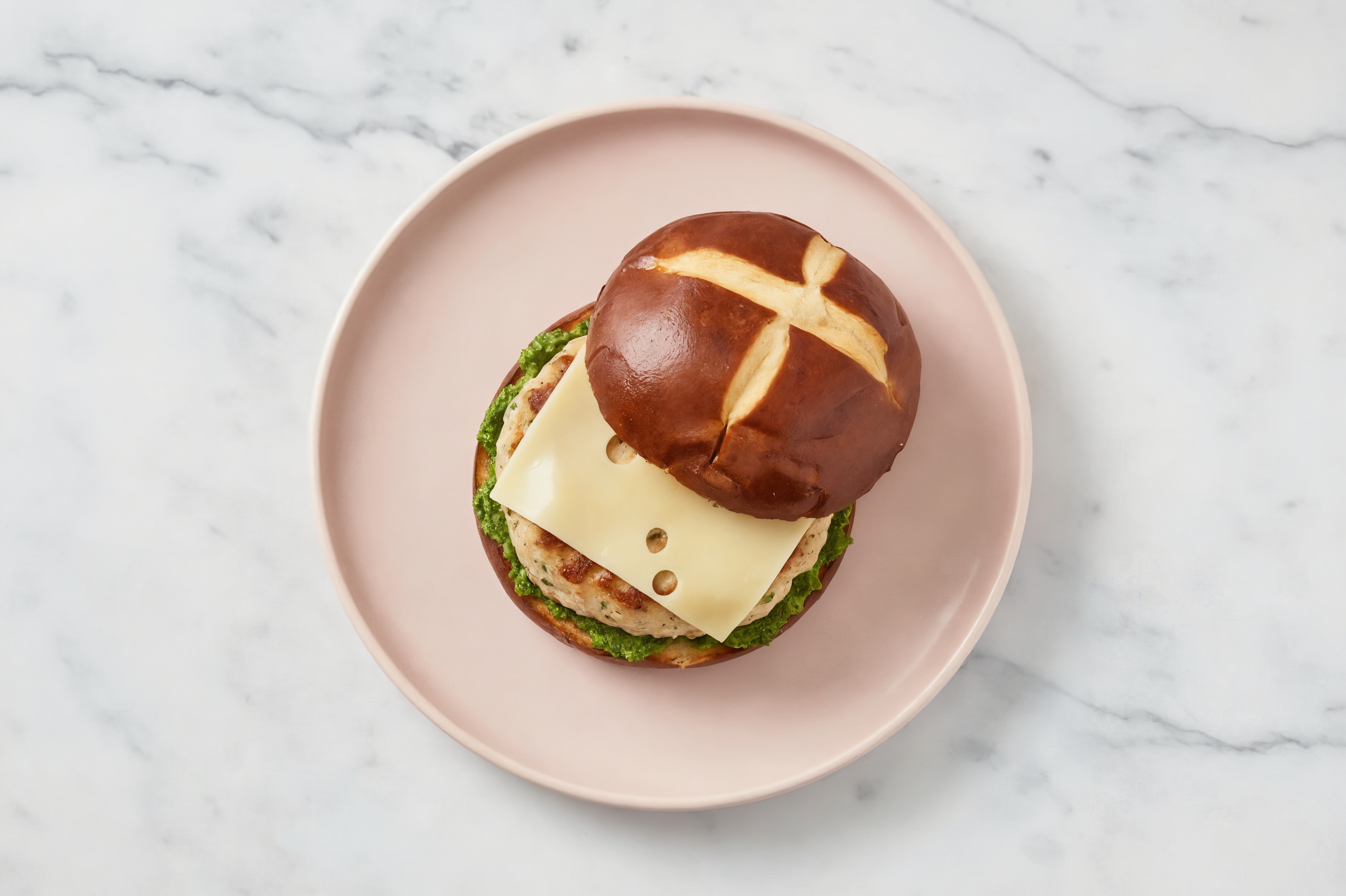 Garlic Chicken Burger on Pretzel with Spinach Pesto & Swiss