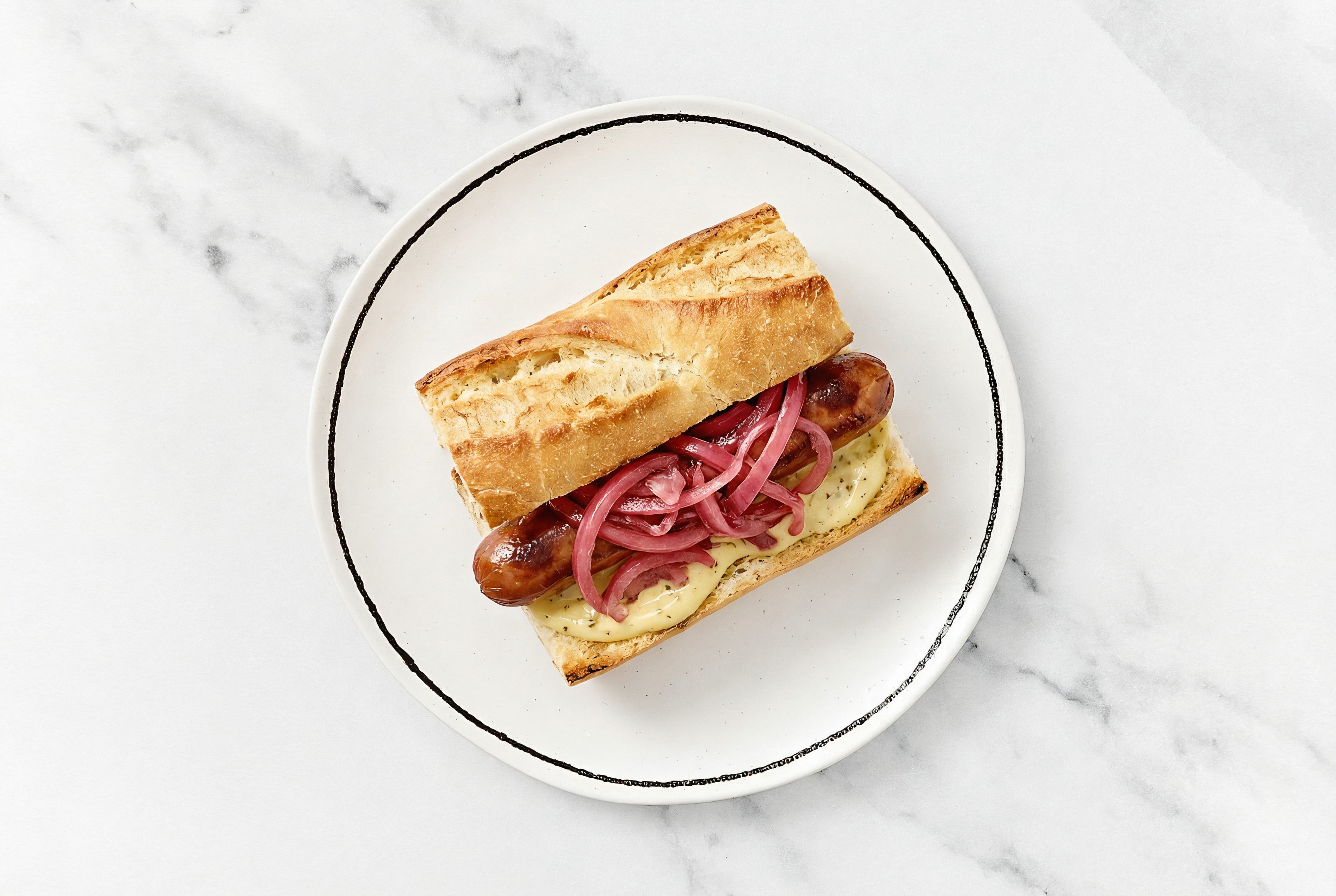 Pickled Red Onion Beef Hot Dog with Honey Musard Garlic Sauce on Baguette