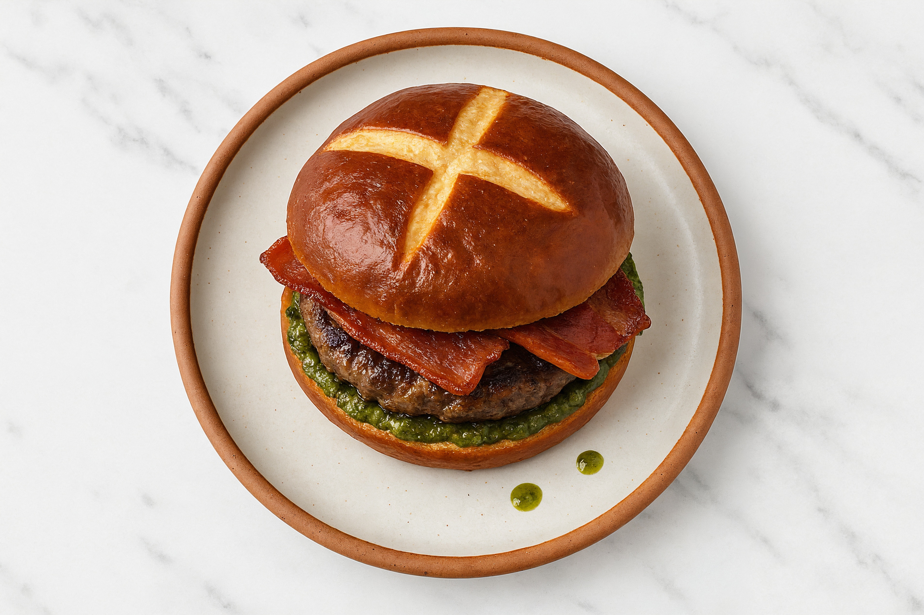 Ground Lamb Burger on Pretzel with Spinach Pesto & Turkey Bacon