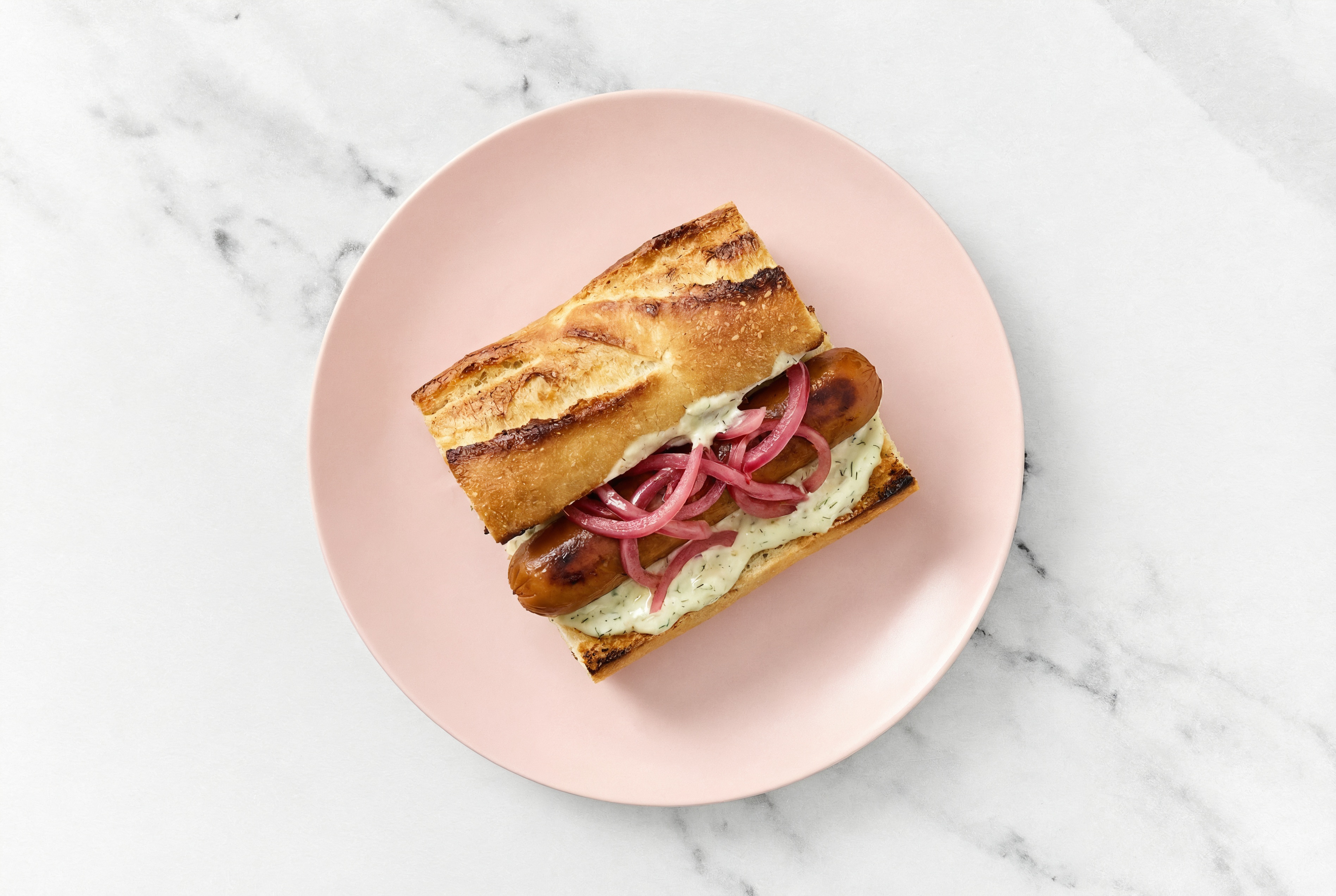 Pickled Red Onion Smart Dog with Garlic Sauce on Baguette