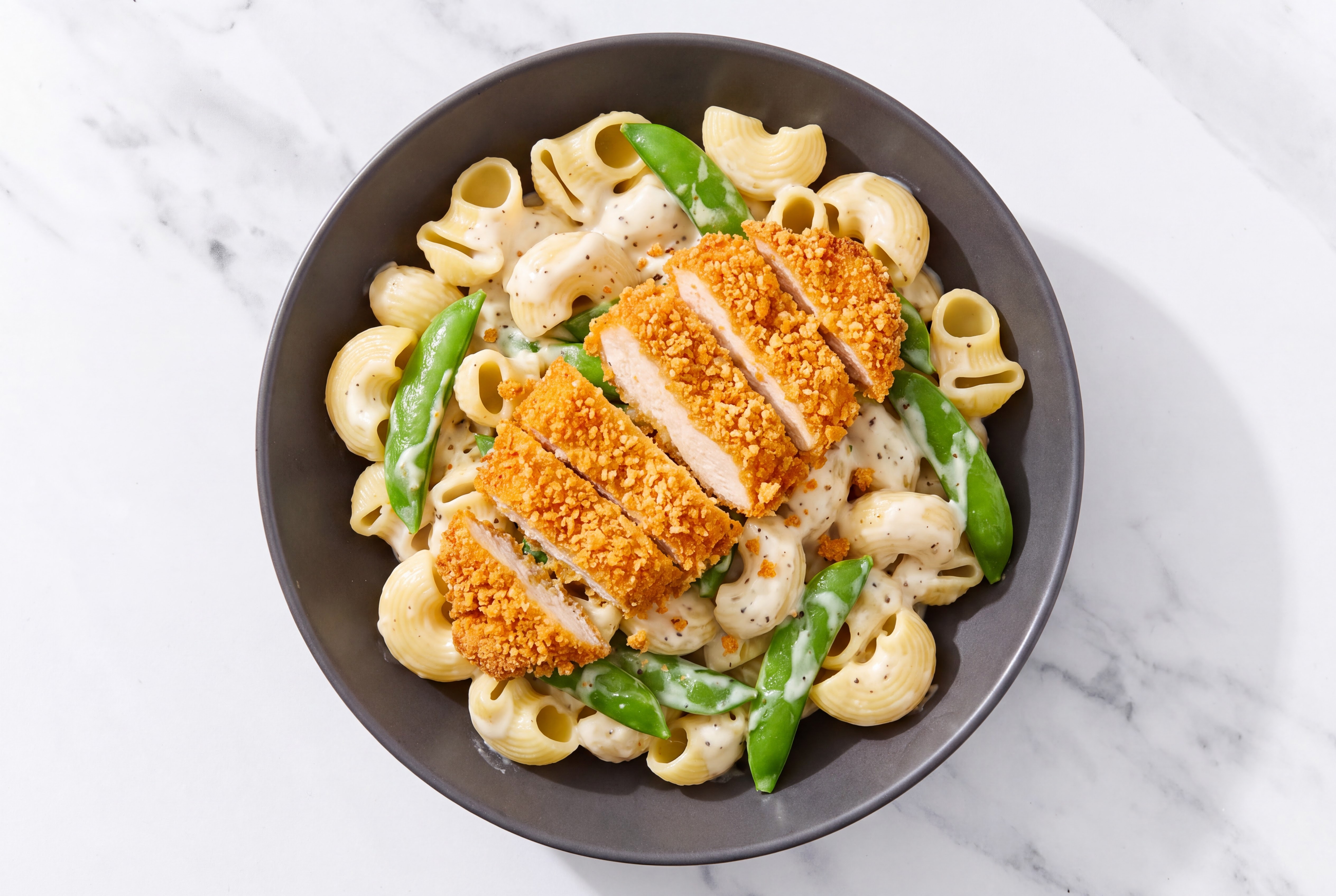Crispy Hot Honey Chicken over Alfredo Chiocciole Pasta with Snap Peas