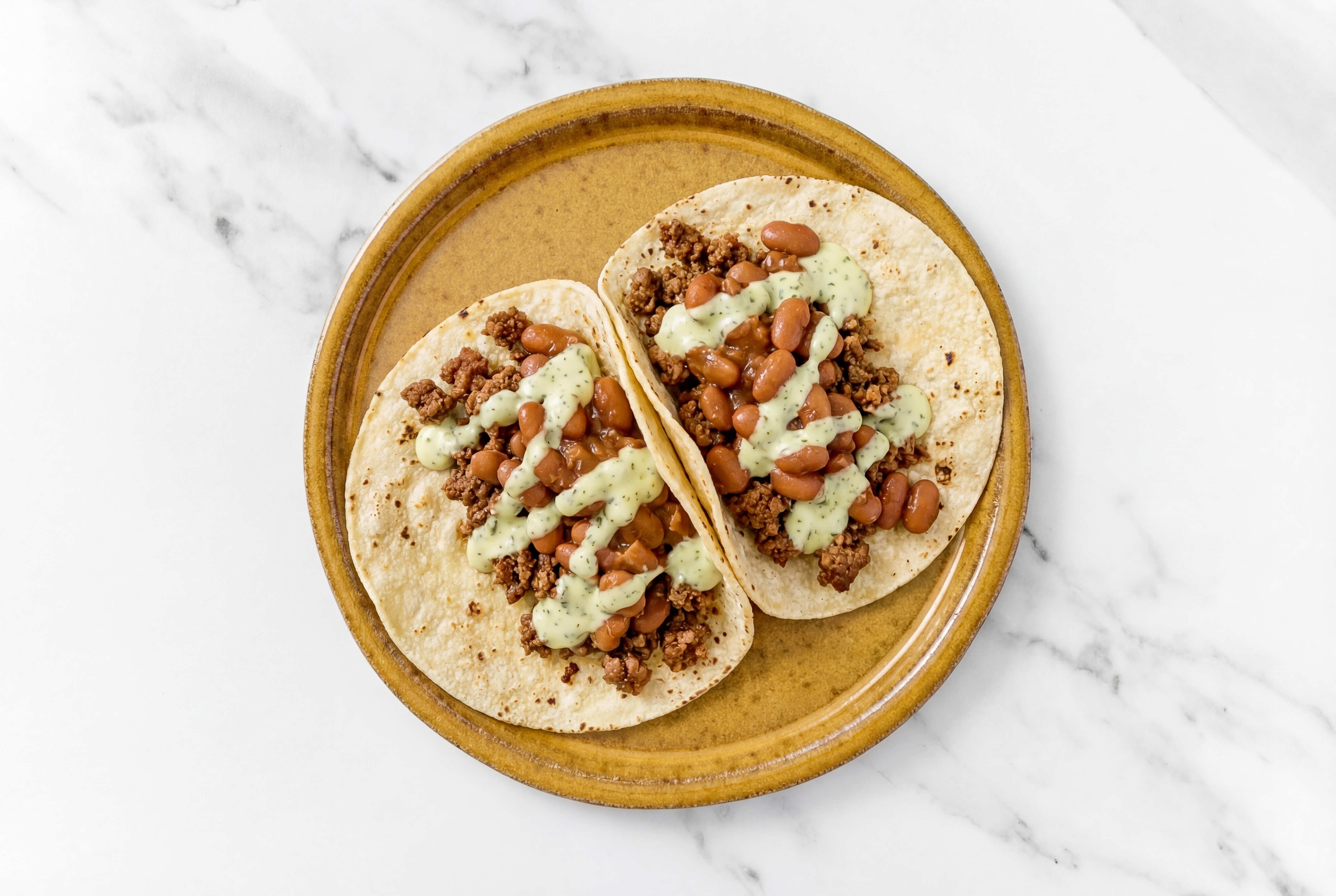 Hearty Mexican-Style Ground Beef Tacos with Jalapeño Crema & Pinto Beans