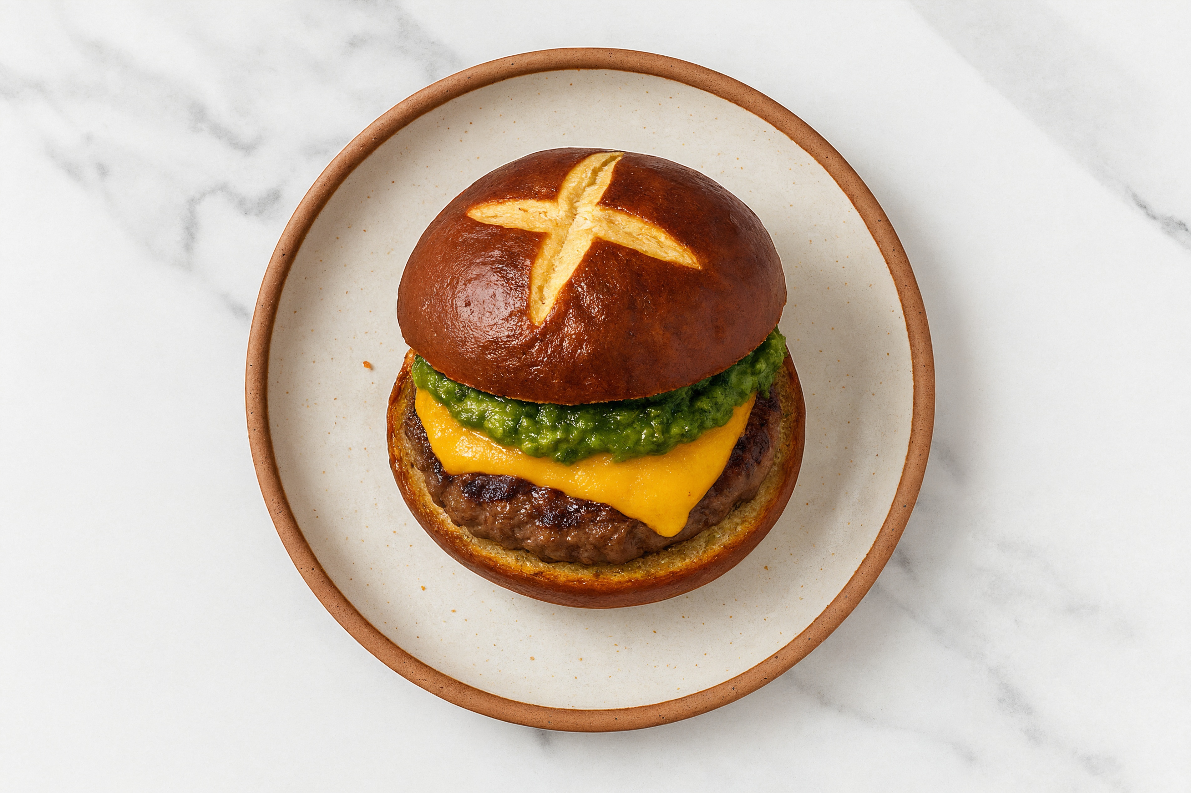 Ground Lamb Burger on Pretzel with Spinach Pesto & Cheddar