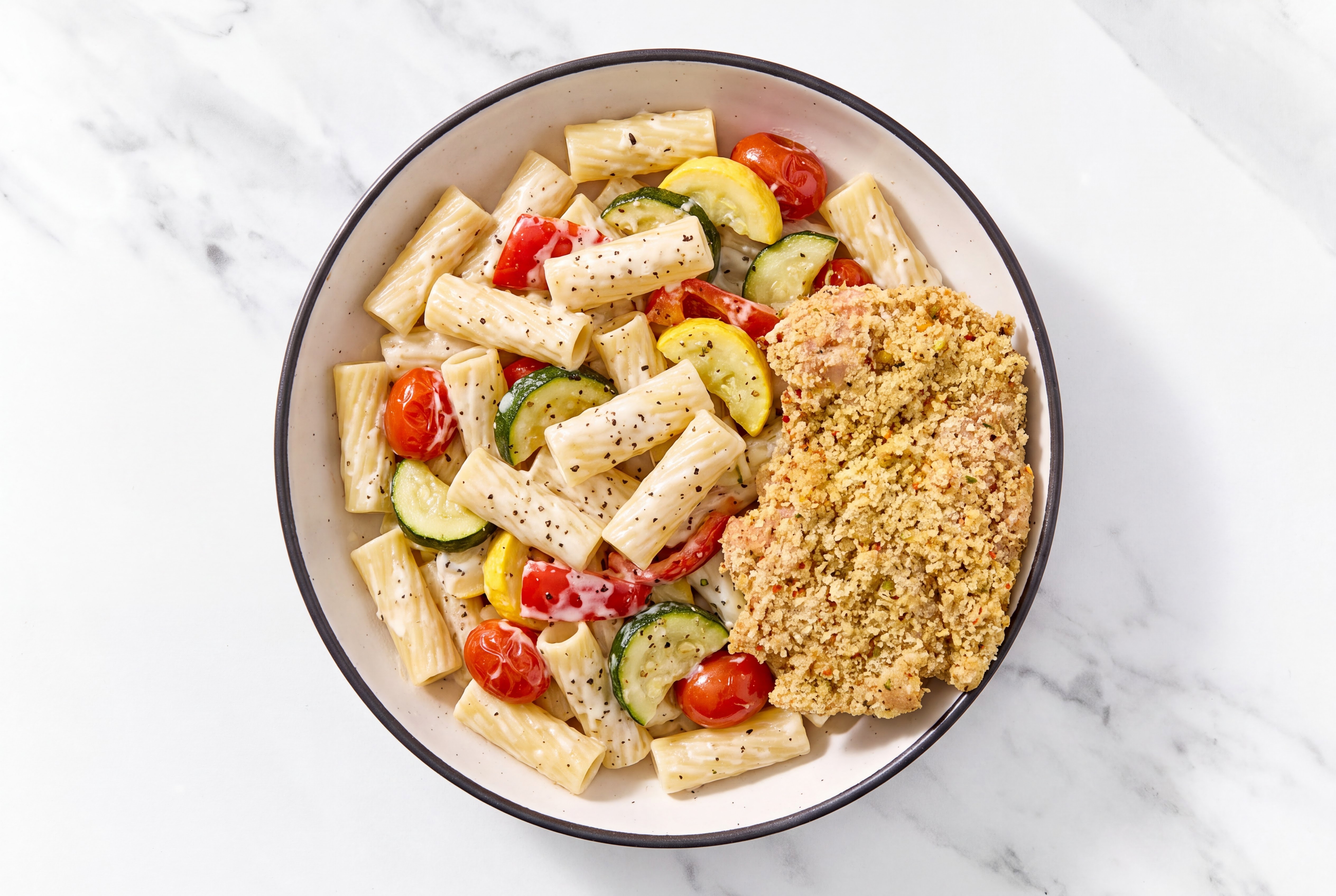 Crispy Garlic Chicken over Alfredo Rigatoni with Mixed Veggies