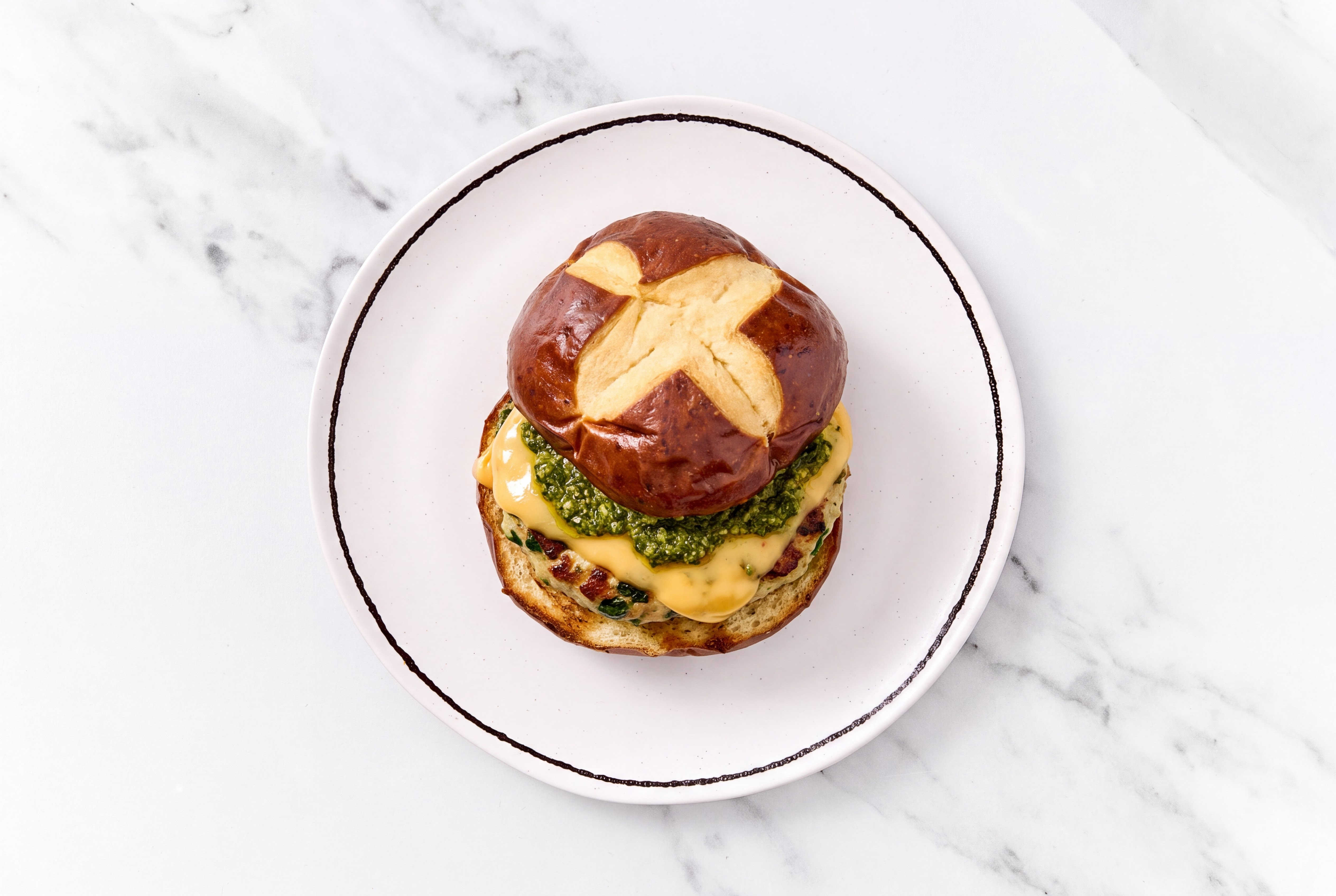Garlic Turkey Burger on Pretzel with Spinach Pesto & American