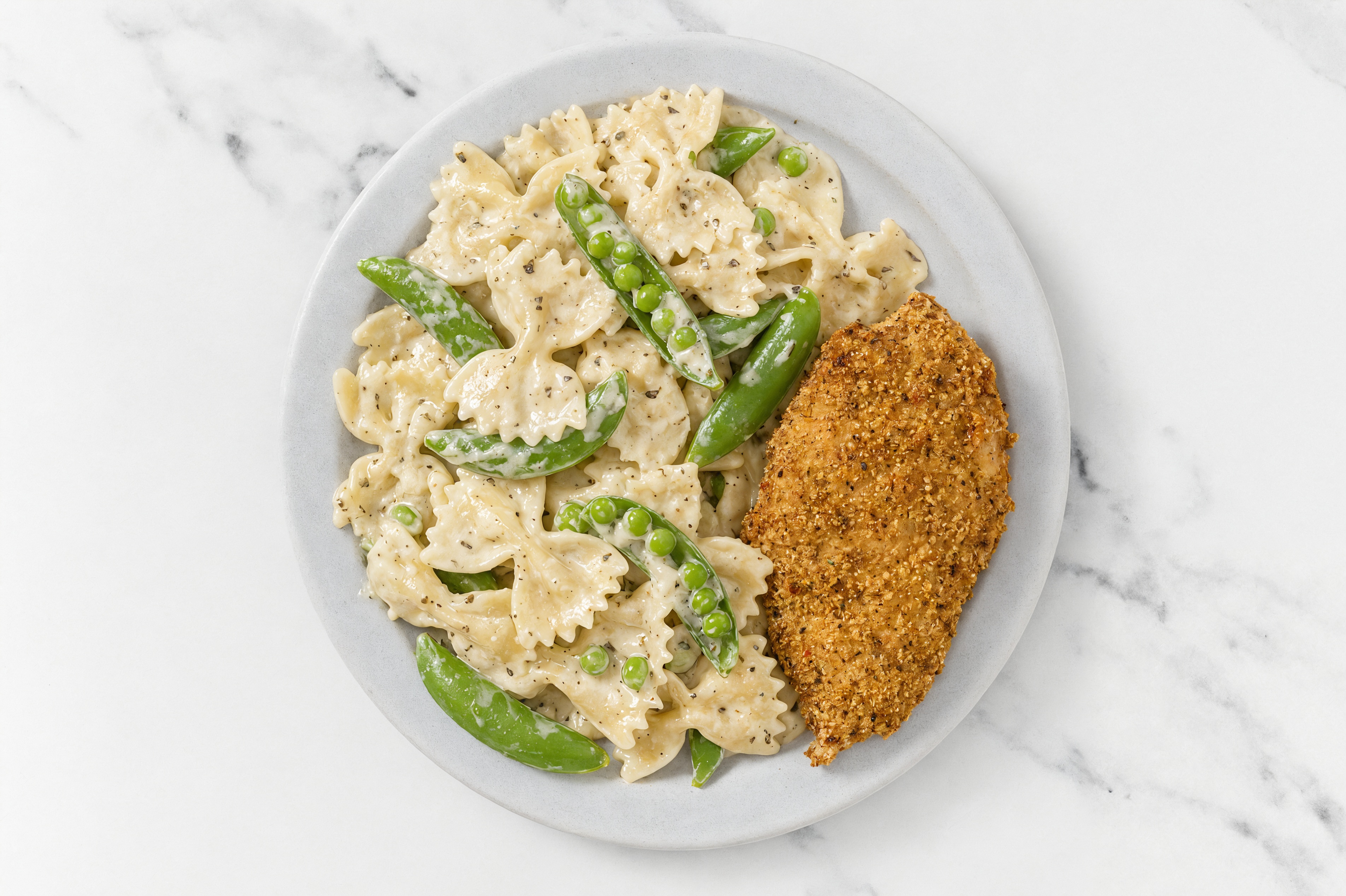 Crispy Garlic Chicken over Alfredo Farfalle with Snap Peas