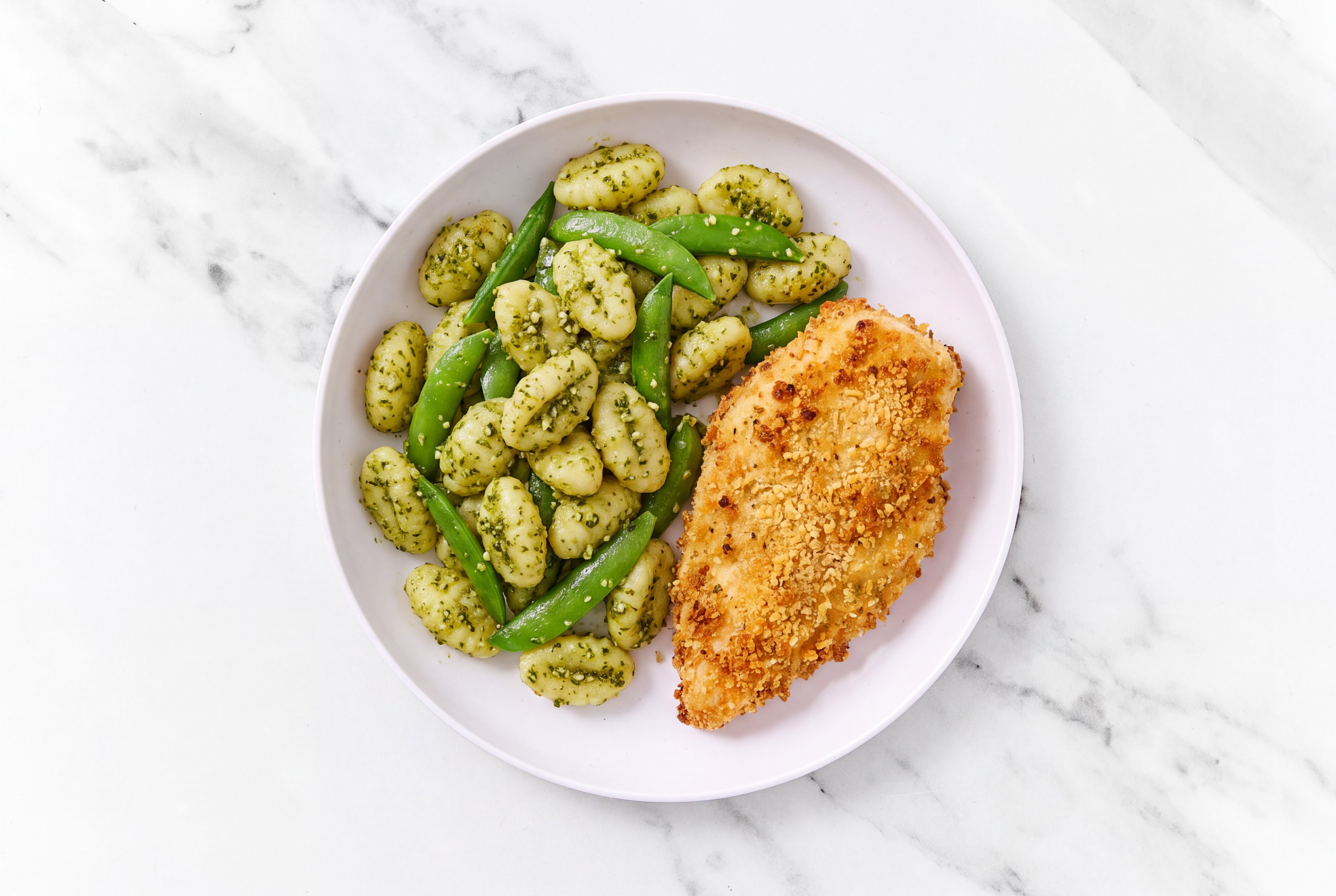 Crispy Garlic Chicken over Pesto Gnocchi with Snap Peas