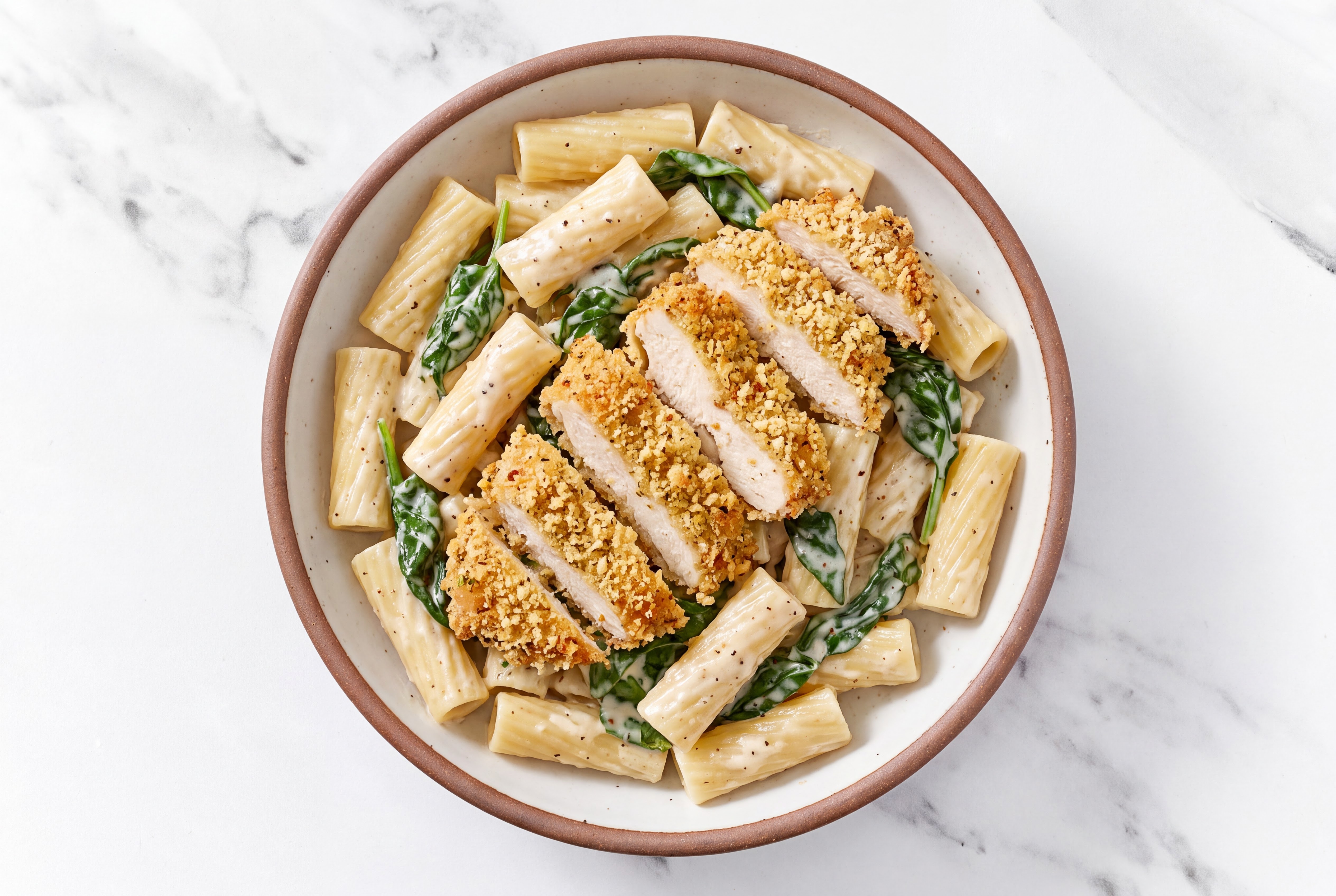 Crispy Garlic Chicken over Alfredo Rigatoni with Baby Spinach
