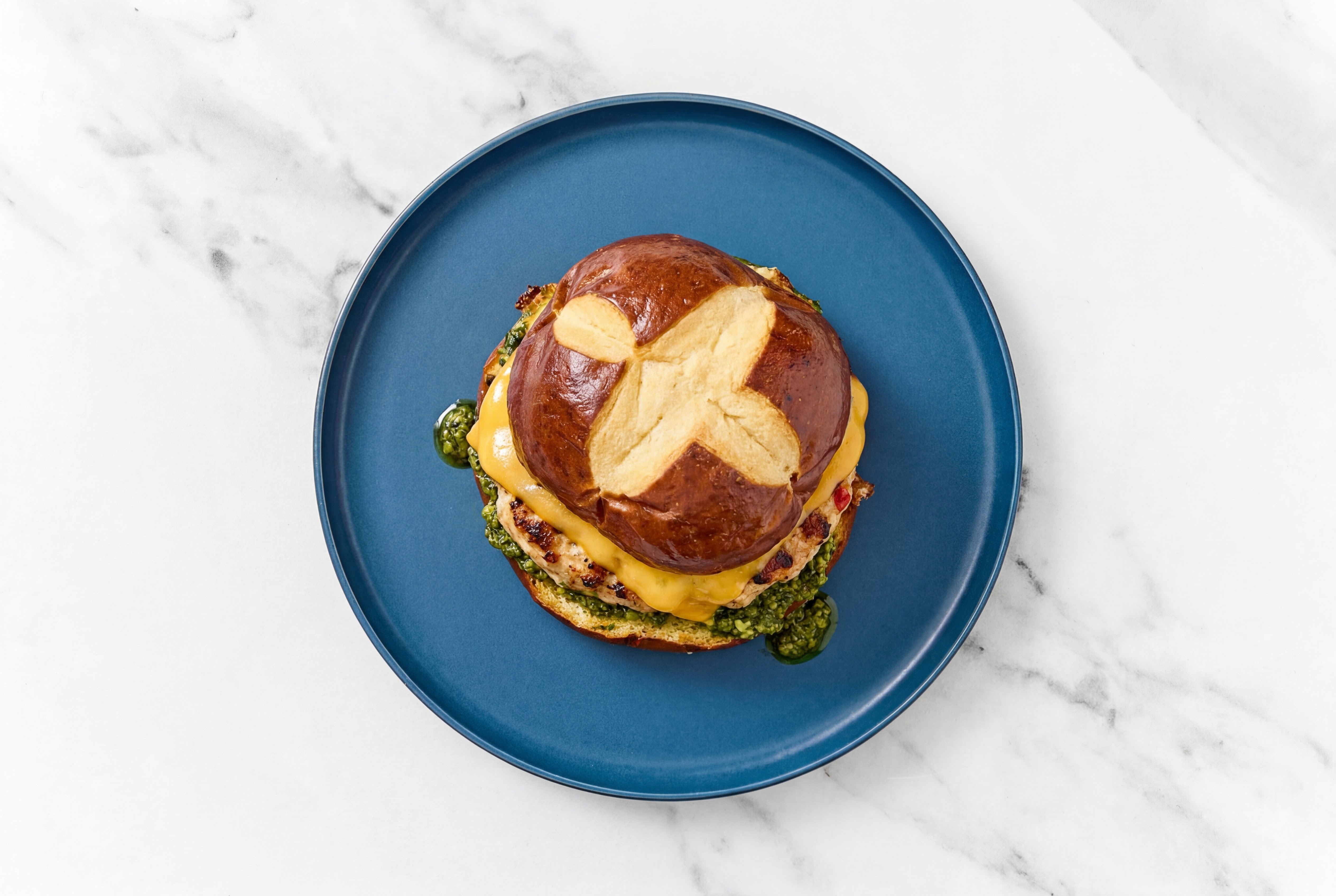 Garlic Chicken Burger on Pretzel with Spinach Pesto & Cheddar