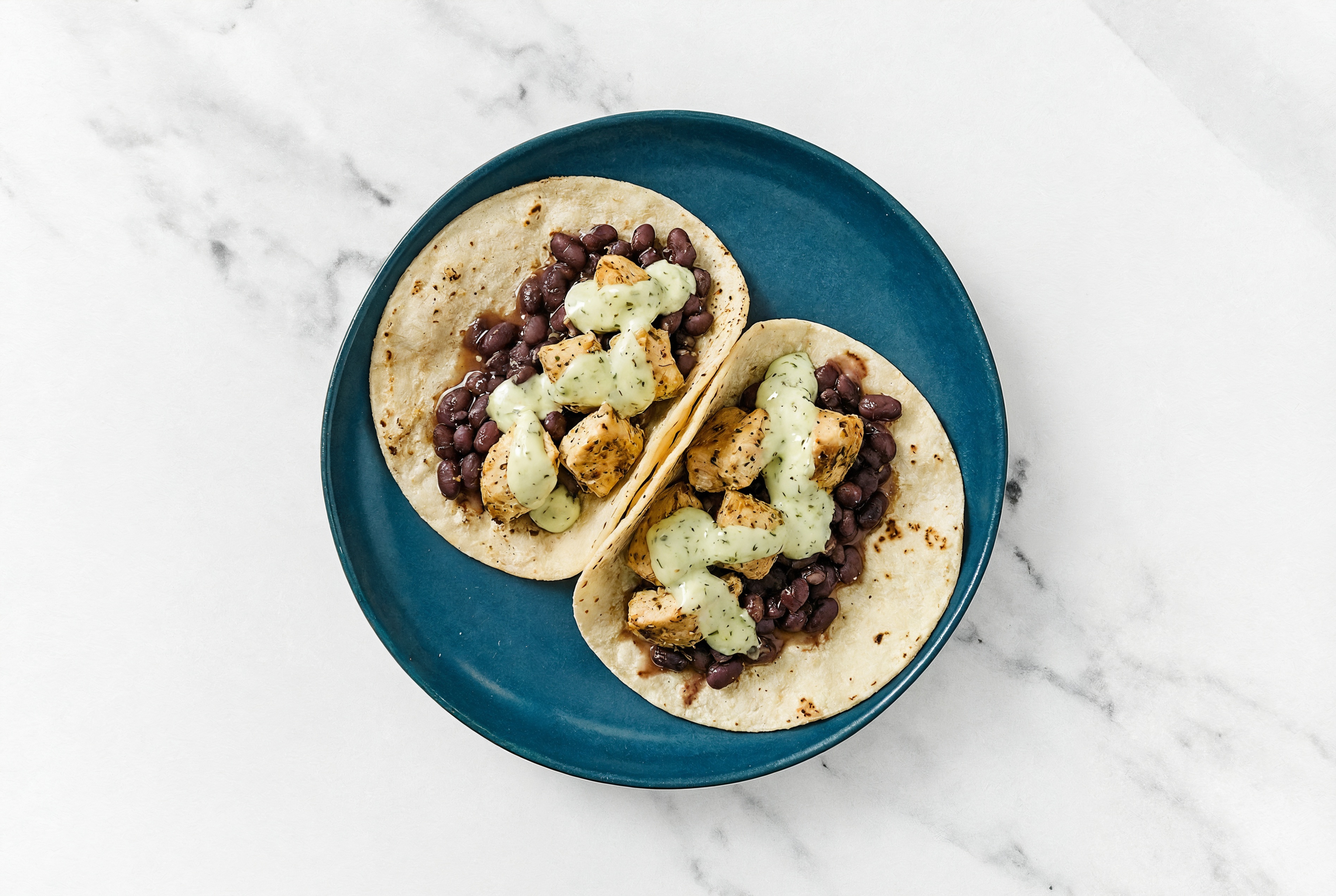 Hearty Garlic Chicken Tacos with Jalapeño Crema & Spiced Beans
