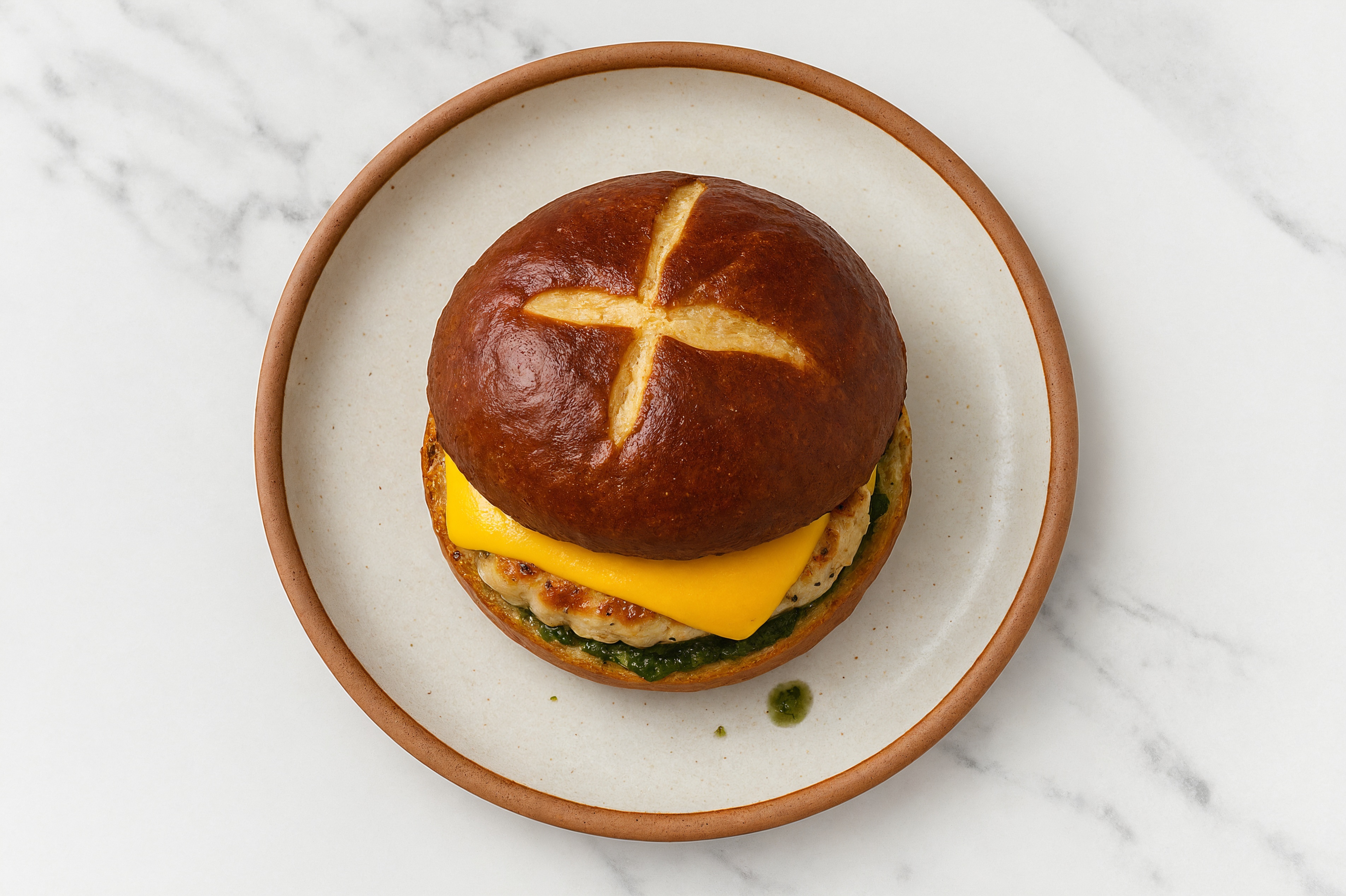 Garlic Chicken Burger on Pretzel with Spinach Pesto & American