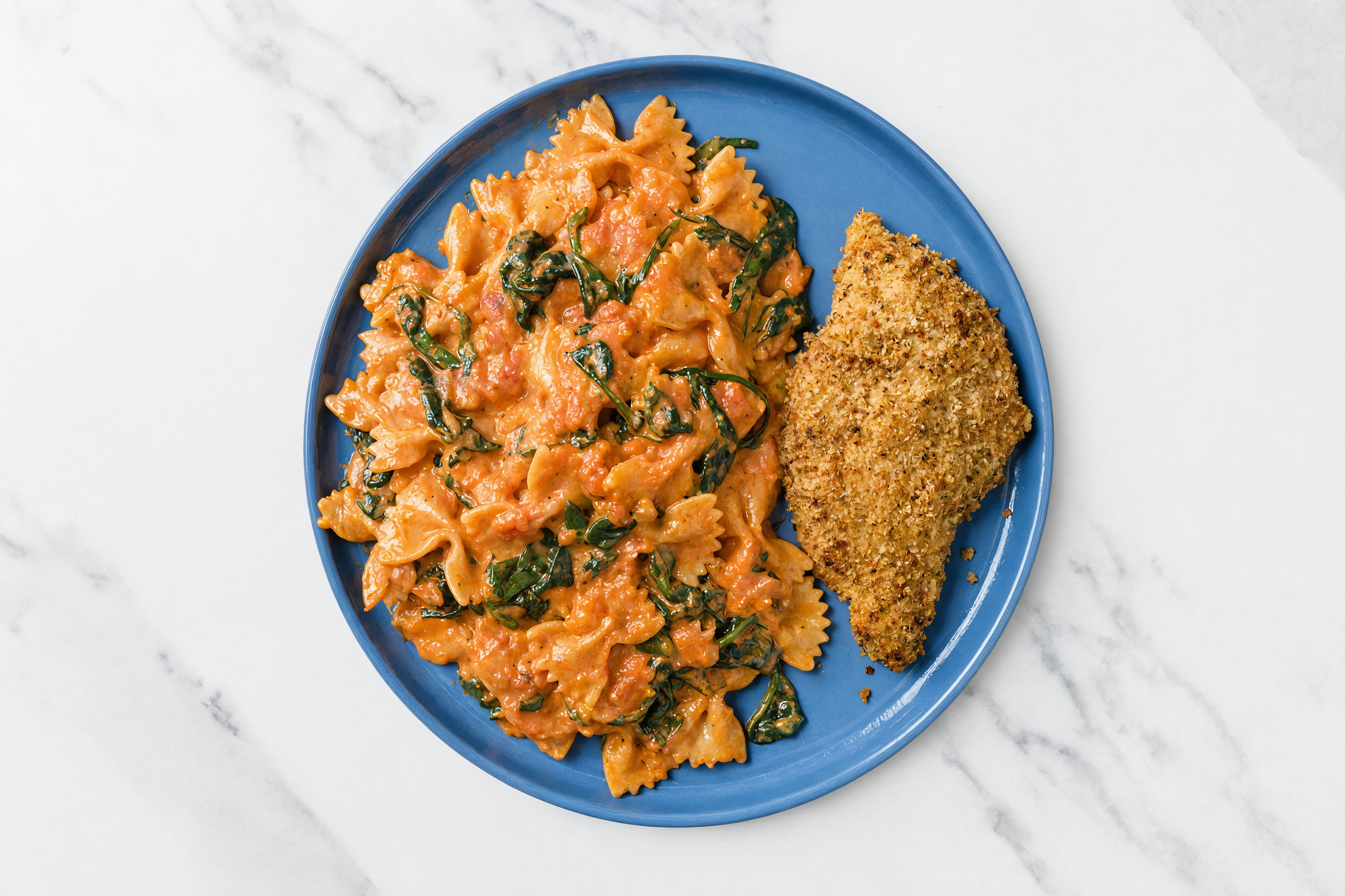 Crispy Garlic Chicken over Creamy Vodka Farfalle with Baby Spinach