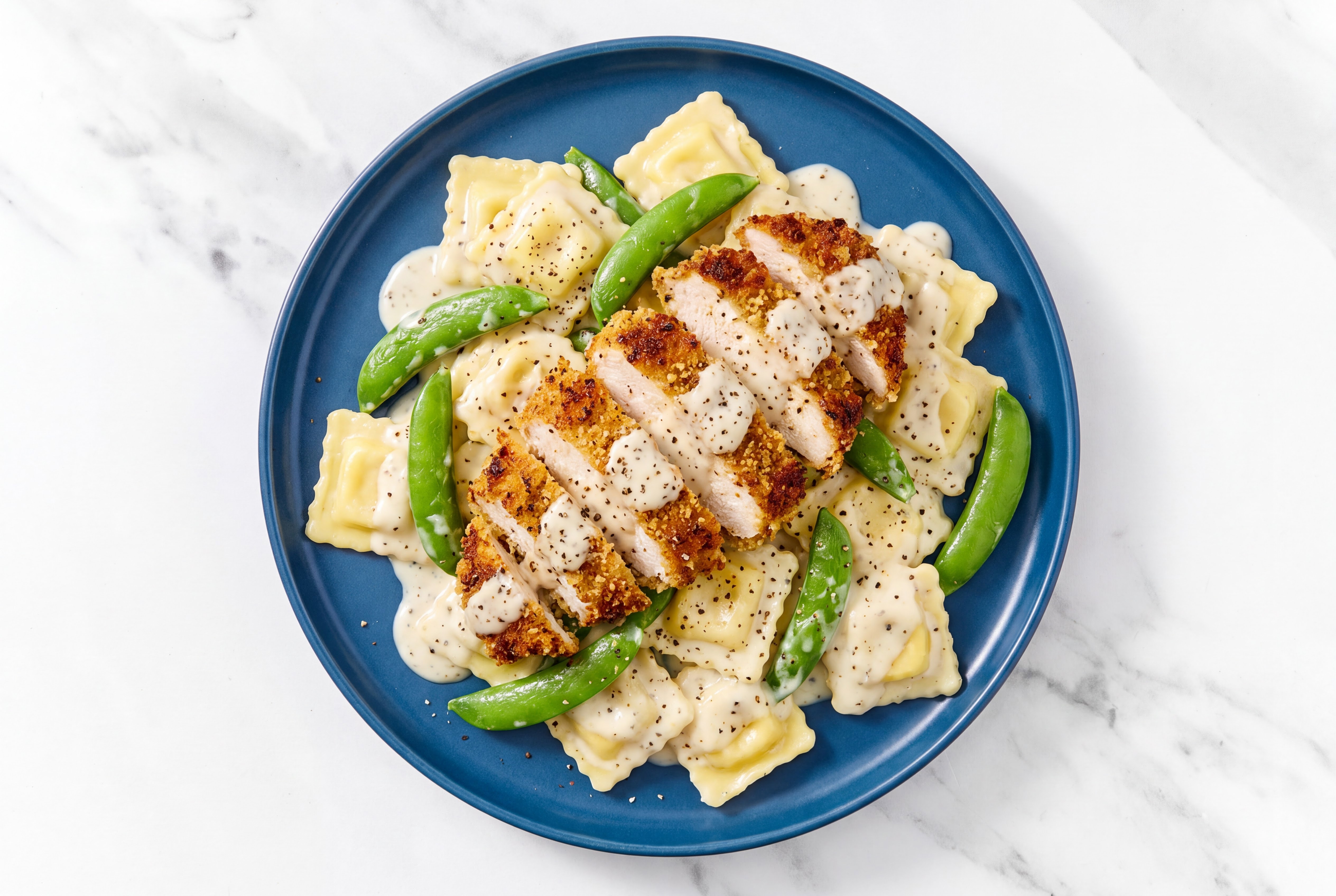 Crispy Garlic Chicken over Alfredo Ravioli with Snap Peas